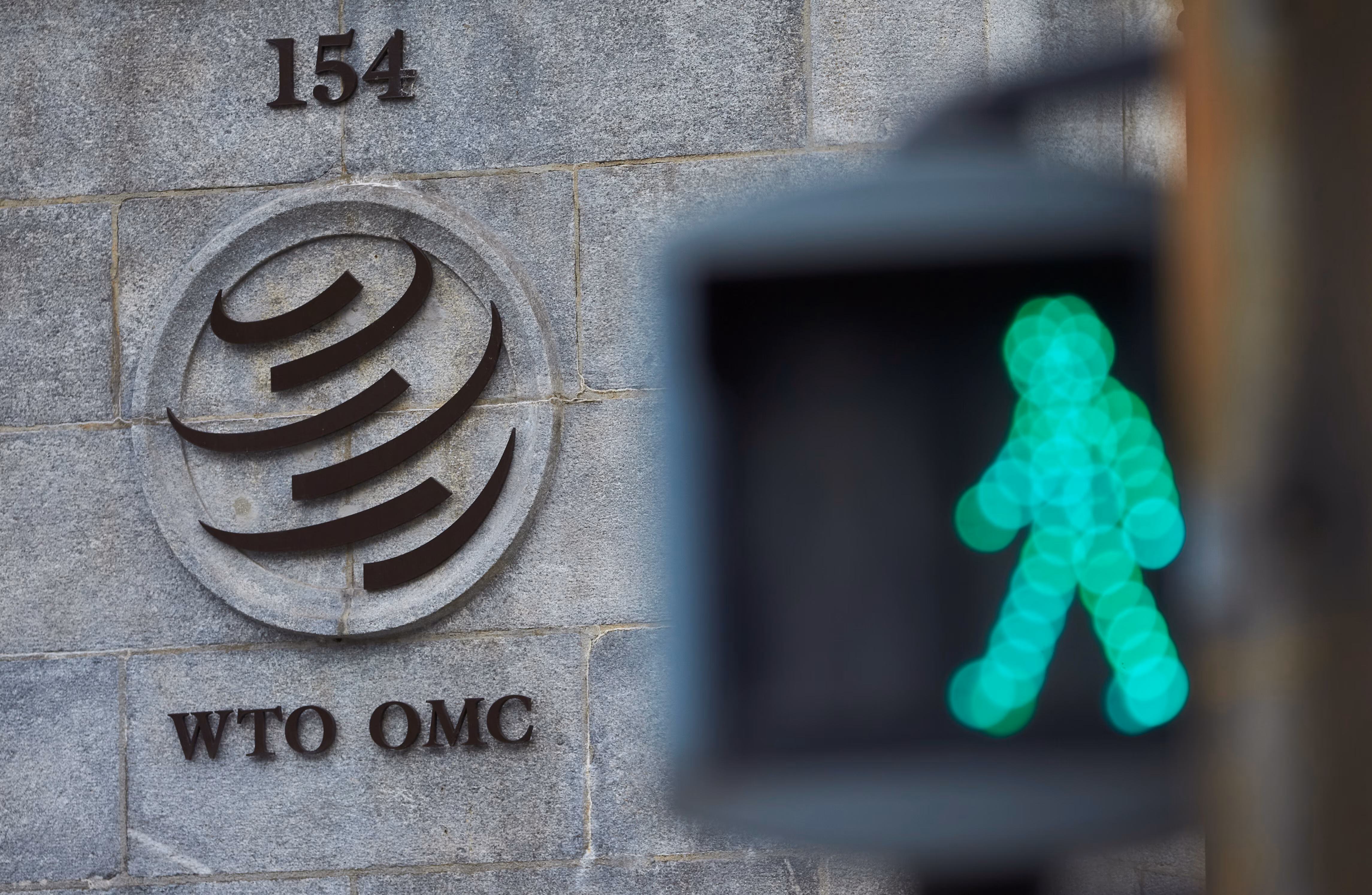 The World Trade Organization building is seen in the background; a green man traffic light is seen in the foreground.
