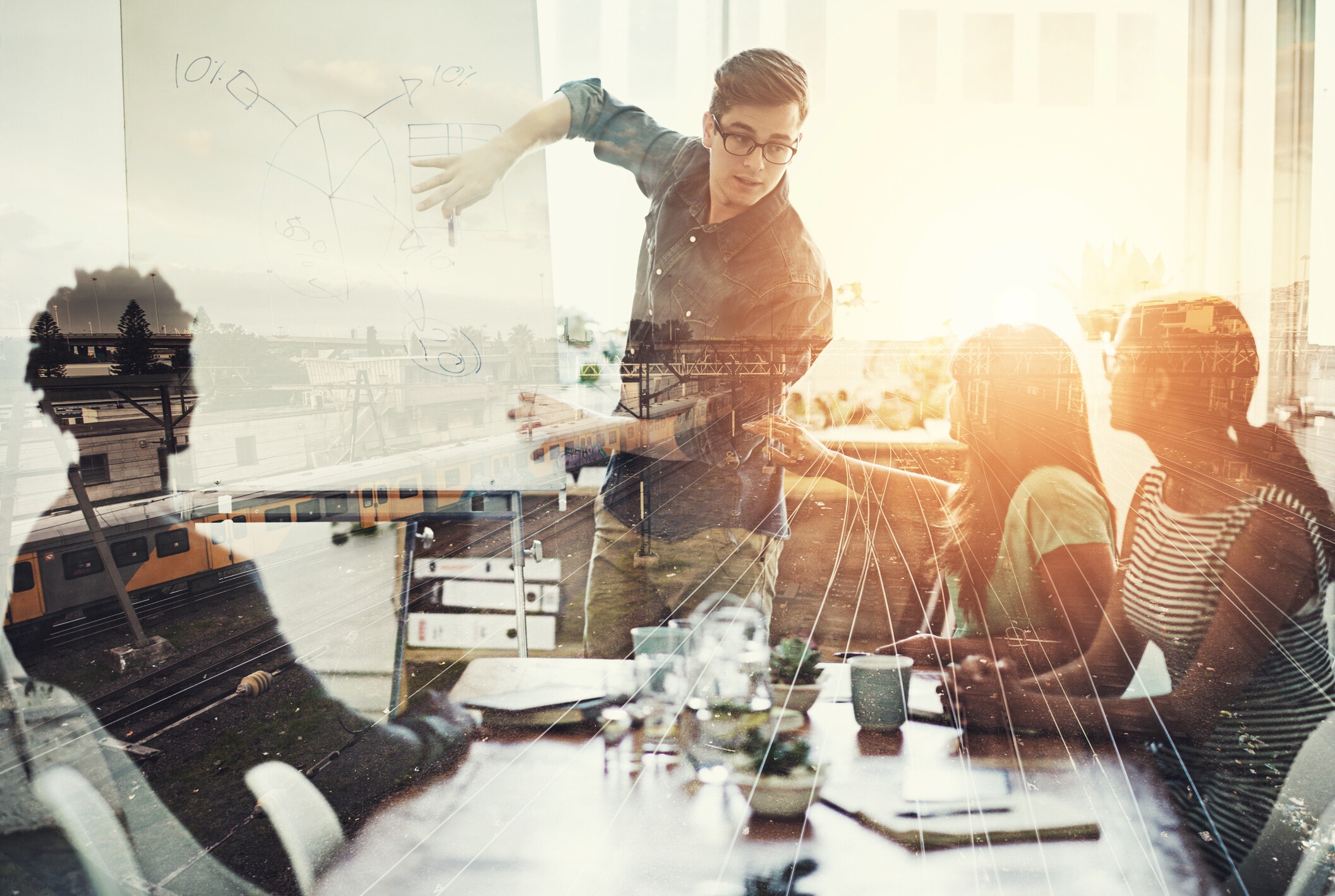 Multiple exposure shot of a business group superimposed over a train track: Entrepreneurship can cultivate durable leadership
