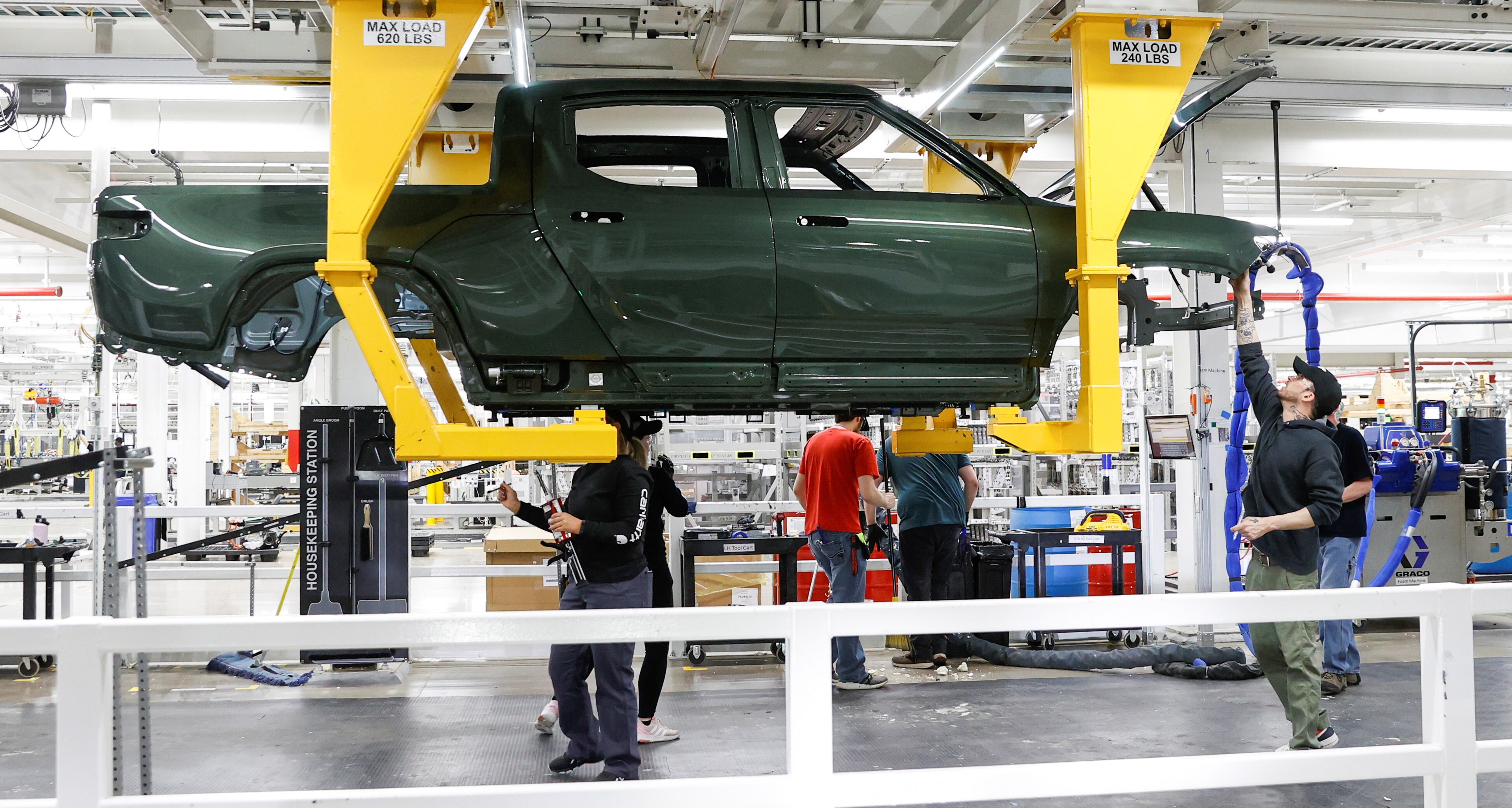 Employees work on an assembly line at startup Rivian Automotive's electric vehicle factory in Normal, Illinois, U.S. April 11, 2022. Picture taken April 11, 2022.  REUTERS/Kamil Krzaczynski