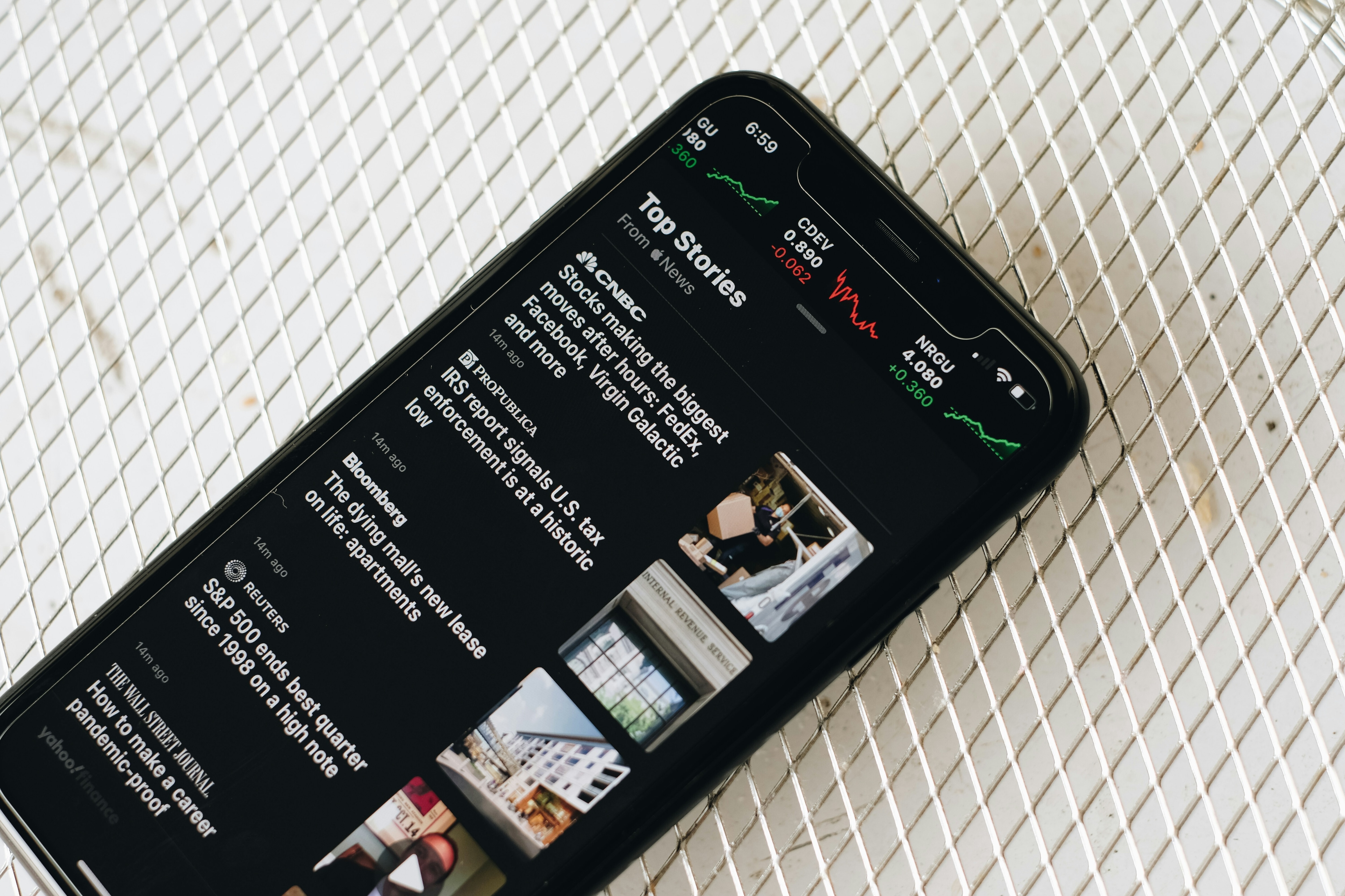 A mobile phone with news alerts displayed on the screen.