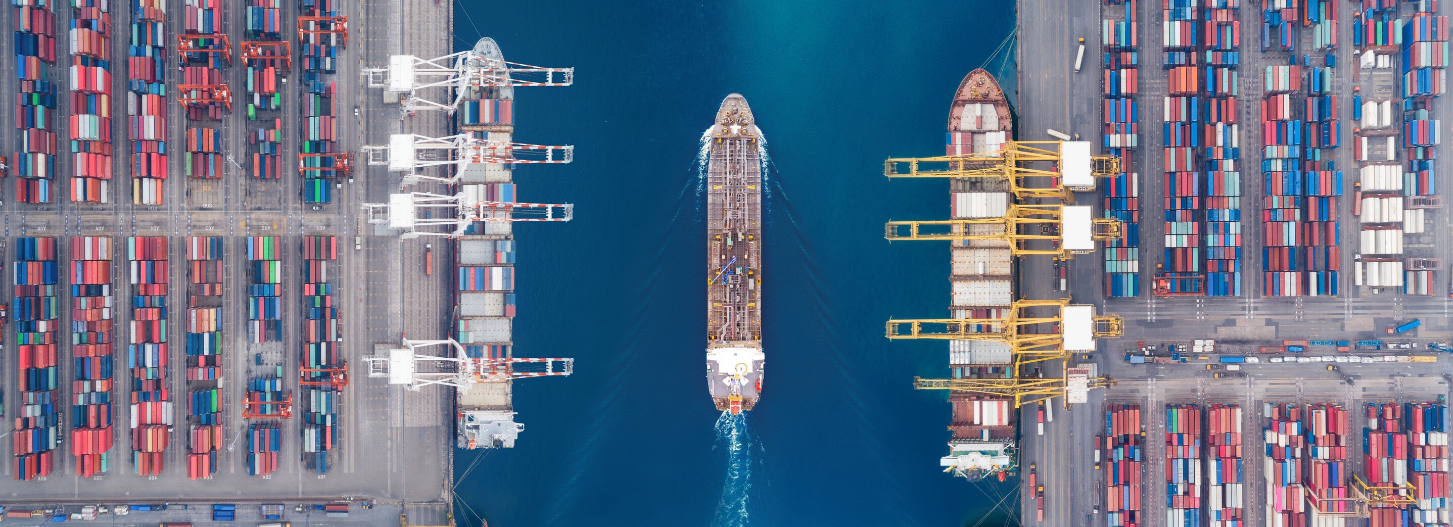 Aerial view panoramic oil tanker moving pass sea port warehouse and container ship or crane ship working for delivery containers shipment. Suitable use for energy power or transport or import export to global logistics concept. supply chain resilience