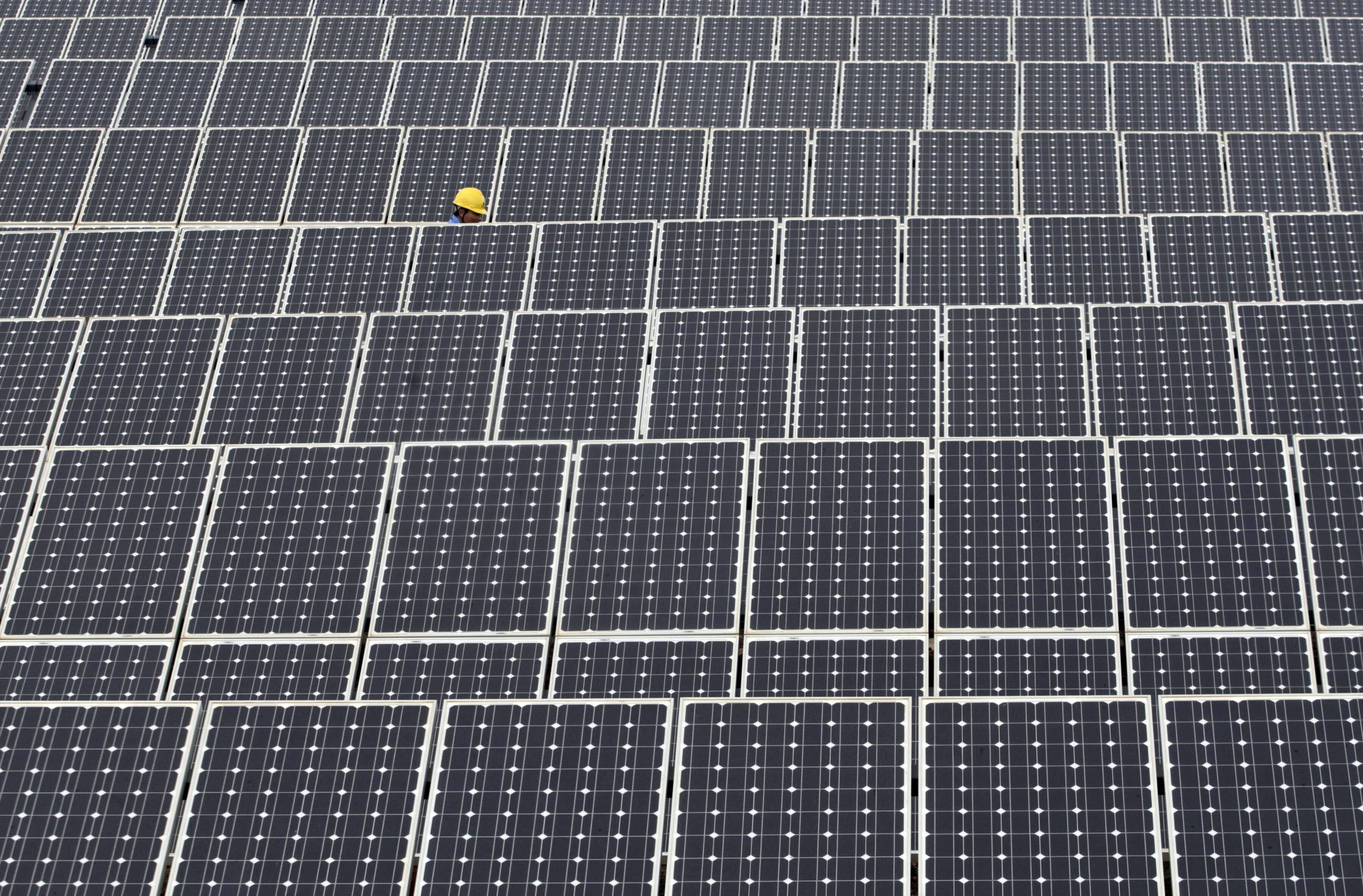 A labourer inspects solar panels at a solar power plant in Kunming, Yunnan province May 25, 2010. China will aim to meet its five-year energy saving and emission reduction goals through 2010 ahead global climate talks at the end of the year, the country's top climate negotiator said. REUTERS/Stringer (CHINA - Tags: ENERGY BUSINESS) CHINA OUT. NO COMMERCIAL OR EDITORIAL SALES IN CHINA