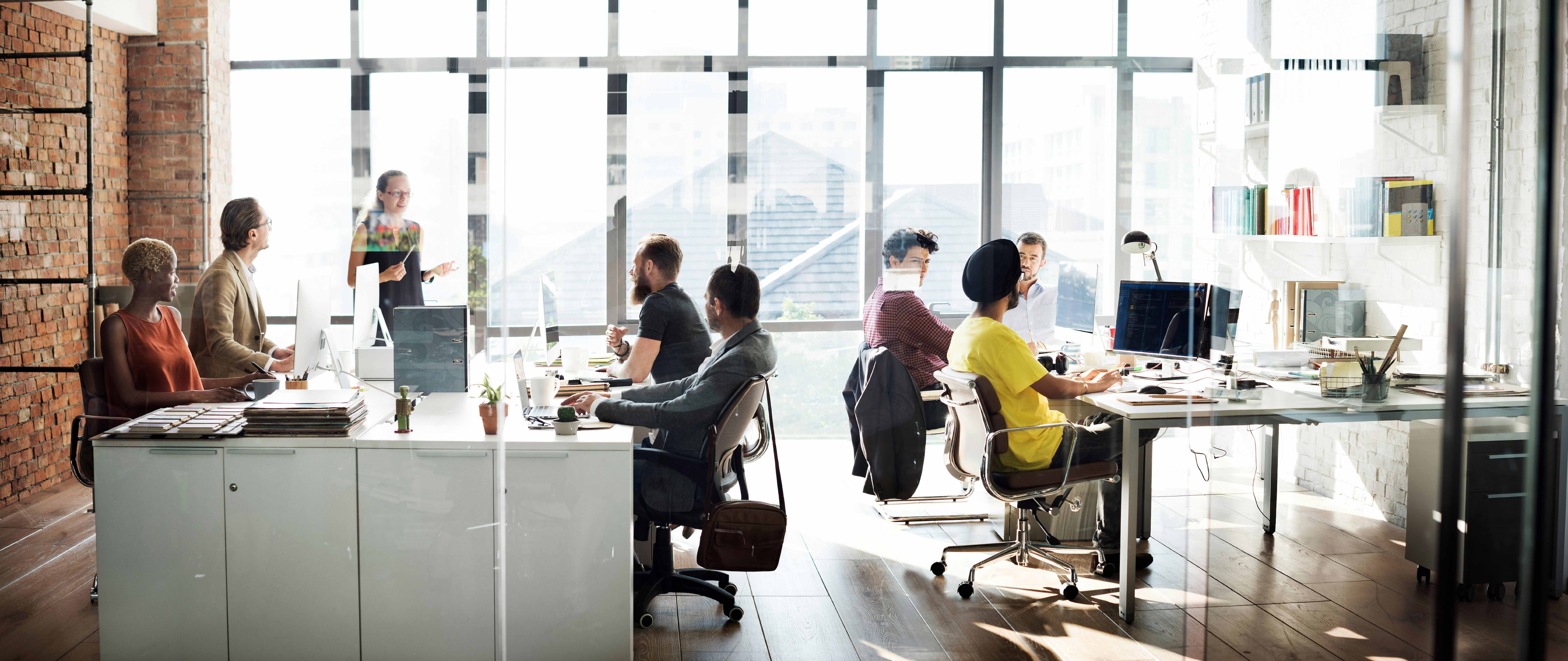 A workplace team in an open plan office as CEOs are encouraged to tackle mental health in the workplace.