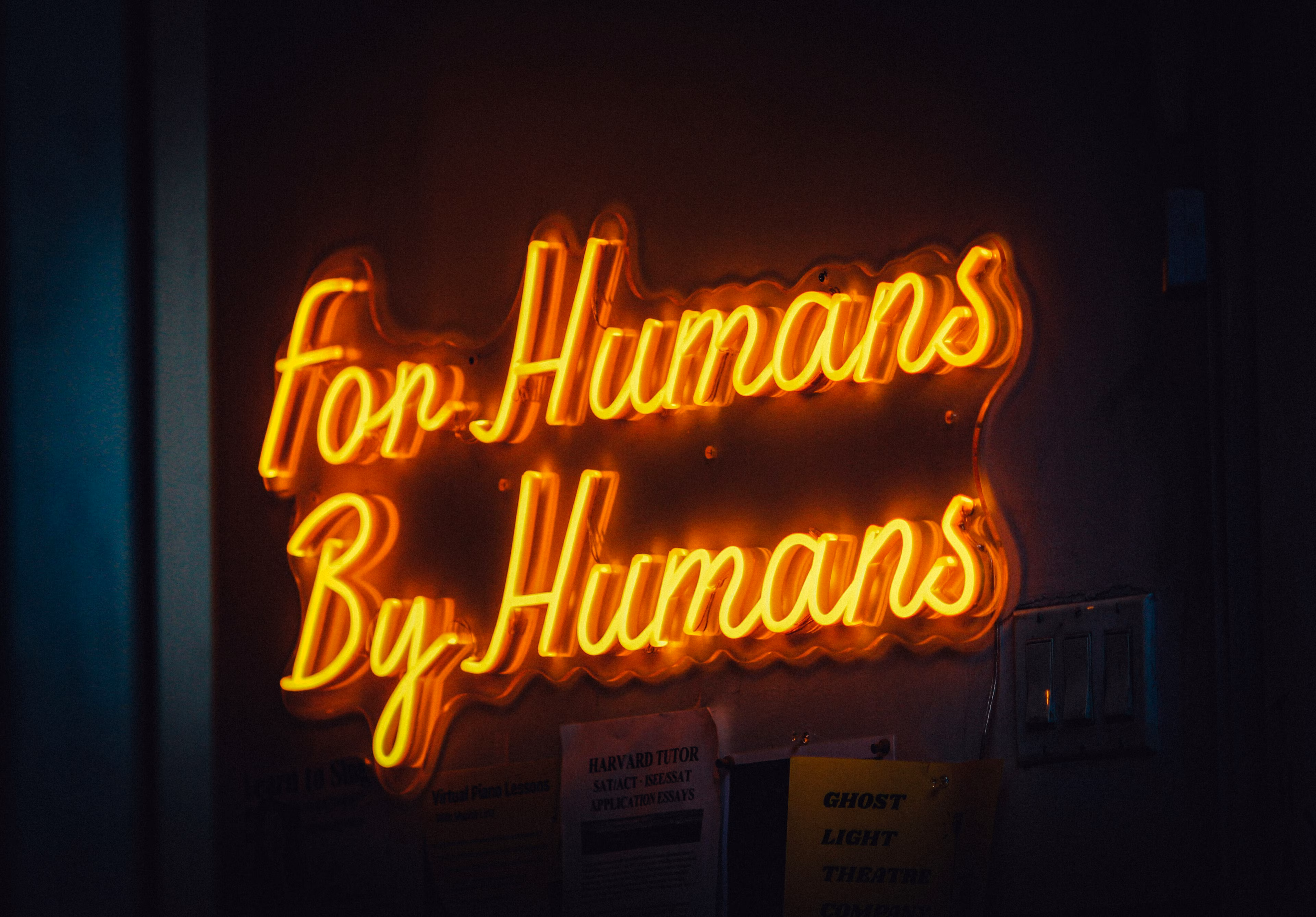 Un letrero de neón con la leyenda "Para humanos, por humanos": la IA centrada en las personas debe surgir de un enfoque que abarque a toda la sociedad.