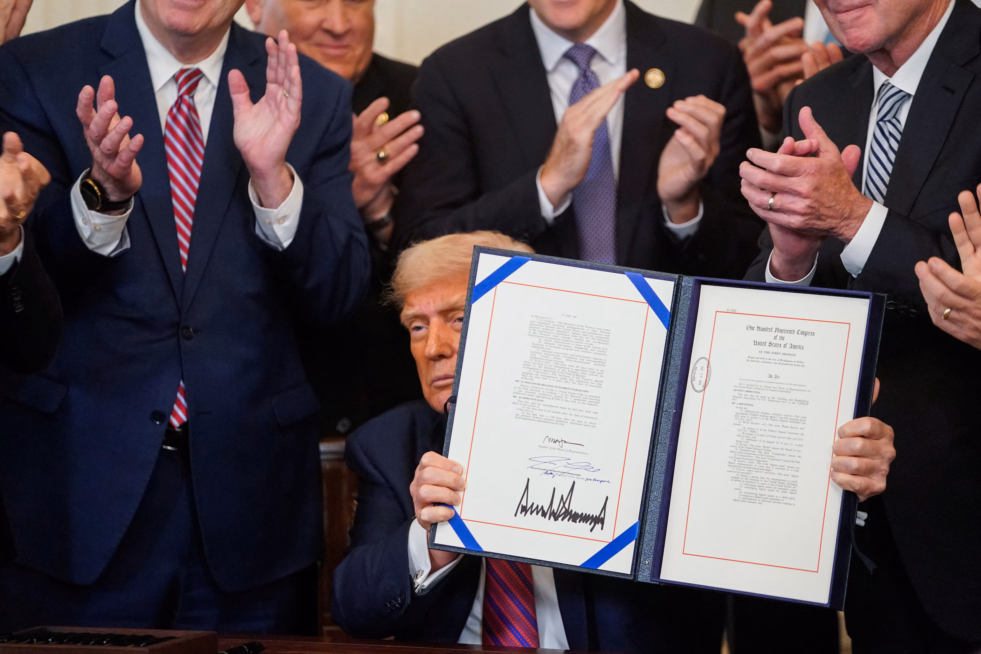 El presidente de Estados Unidos, Donald Trump, sostiene la "Ley Genius" firmada, que desarrollará un marco regulatorio para las criptomonedas estables y ampliará la supervisión de la industria, en la Casa Blanca en Washington, D.C., EE. UU., el 18 de julio de 2025. REUTERS/Nathan Howard