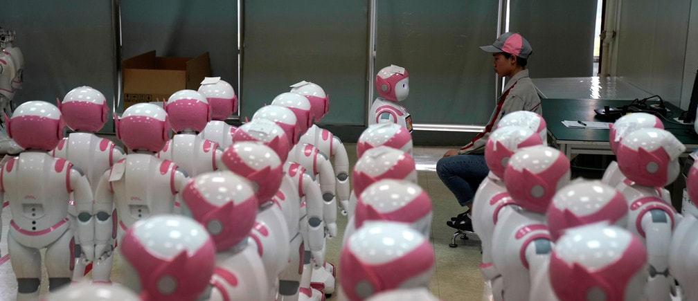 A worker puts finishing touches to an iPal social robot, designed by AvatarMind, at an assembly plant in Suzhou, Jiangsu province, China July 4, 2018. Designed to offer education, care and companionship to children and the elderly, the 3.5-feet tall humanoid robots come in two genders and can tell stories, take photos and deliver educational or promotional content. Picture taken July 4, 2018.REUTERS/Aly Song - RC12AA5524B0