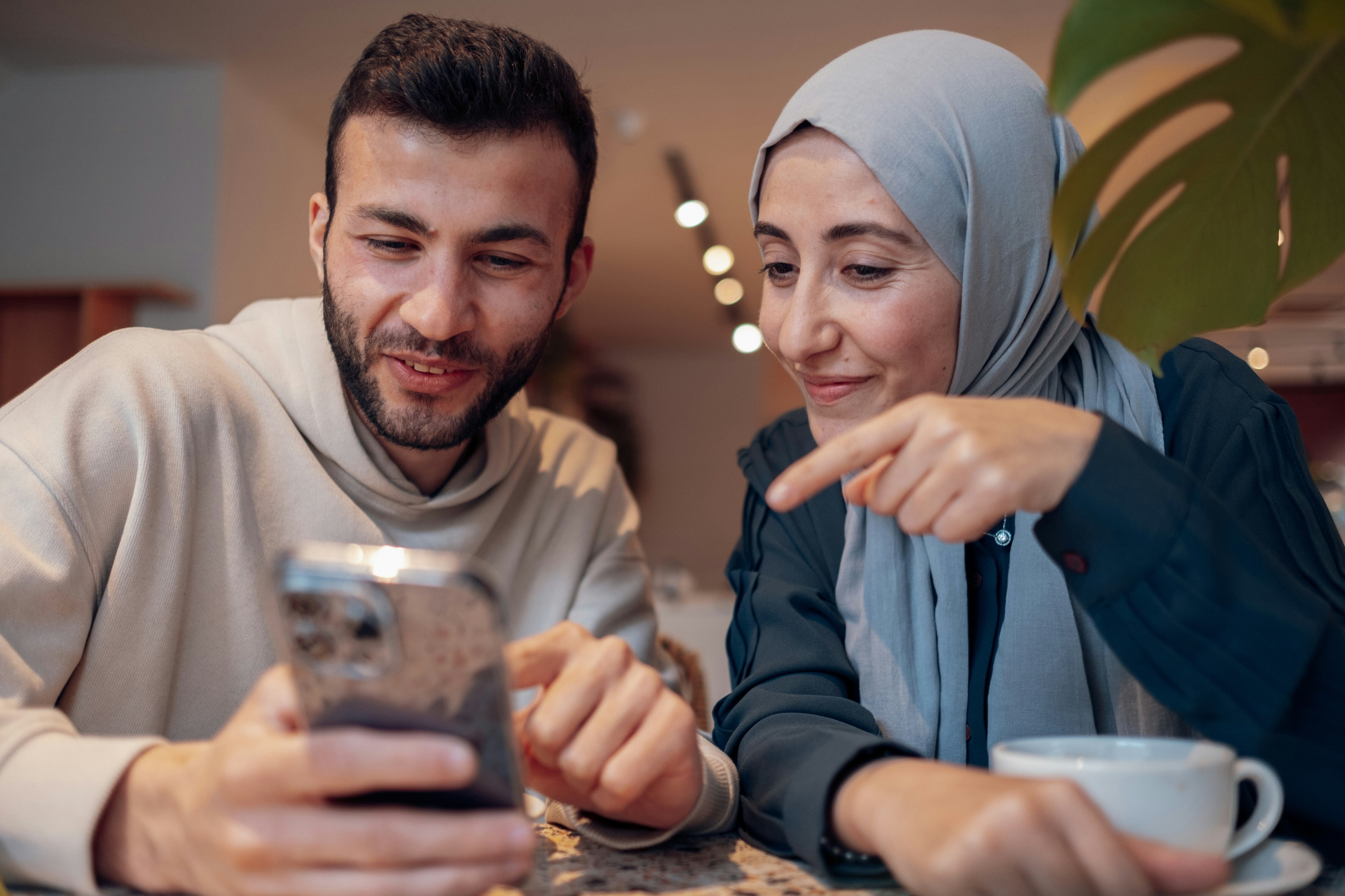 Two people look at a smartphone, AI era