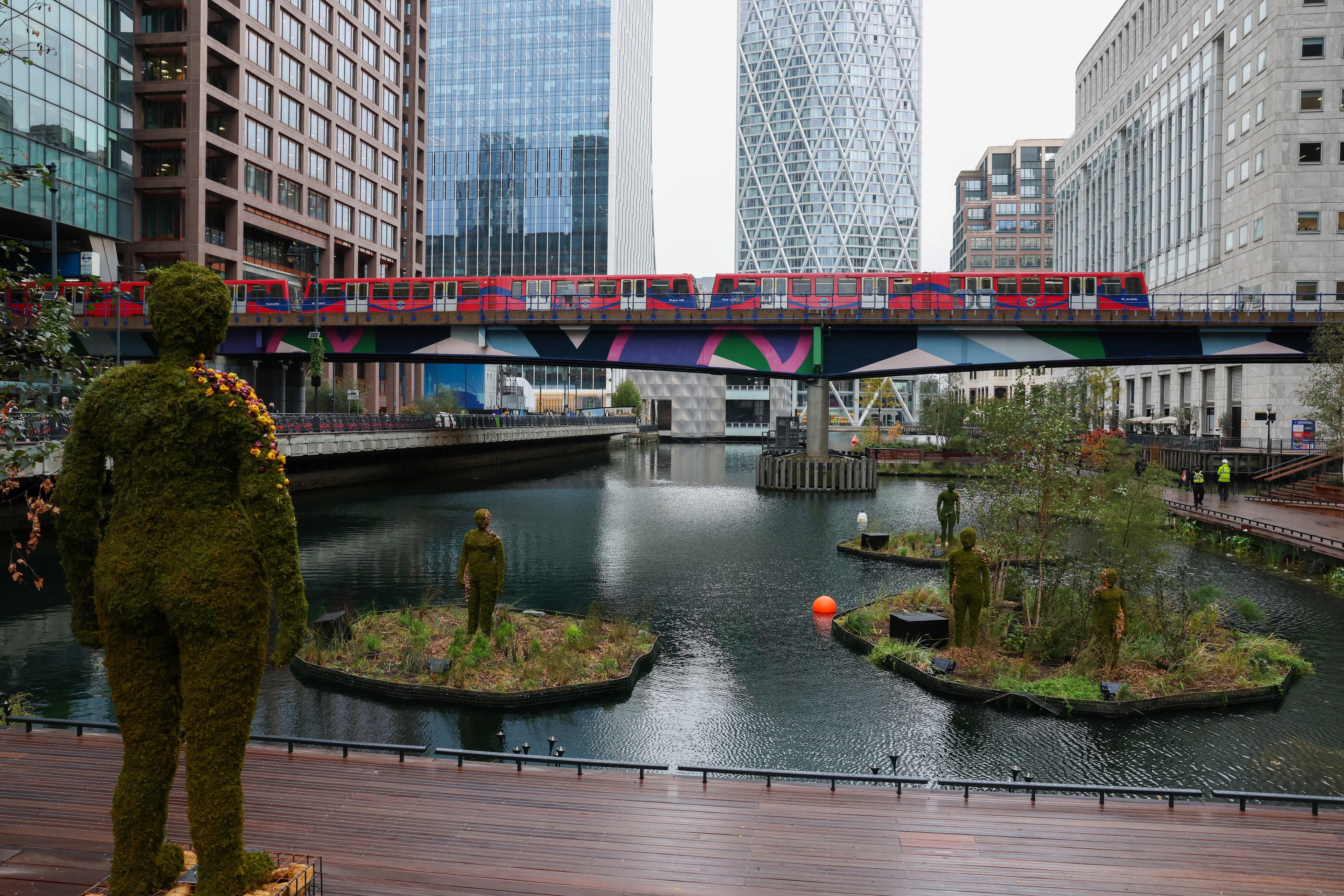 A Docklands Light Railway train passes over the new Eden Dock development as Canary Wharf opened a new waterfront decking area to the public as part of a wider push to green the estate in the financial and business district in London, Britain, October 2, 2024. Smart use of cities' budgets can move the needle on climate adaptation.