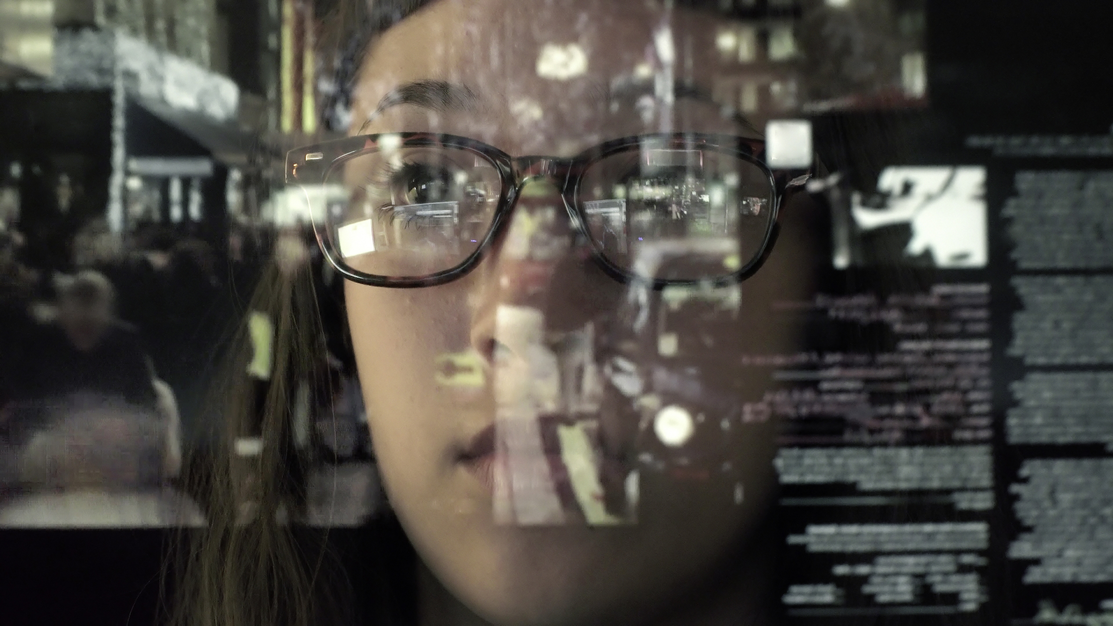 An asian woman concentrating on a touch screen display. The point of view is from behind the screen, looking through the data & images to the woman's face and hands as she manipulates the windows of information. Reading health news
