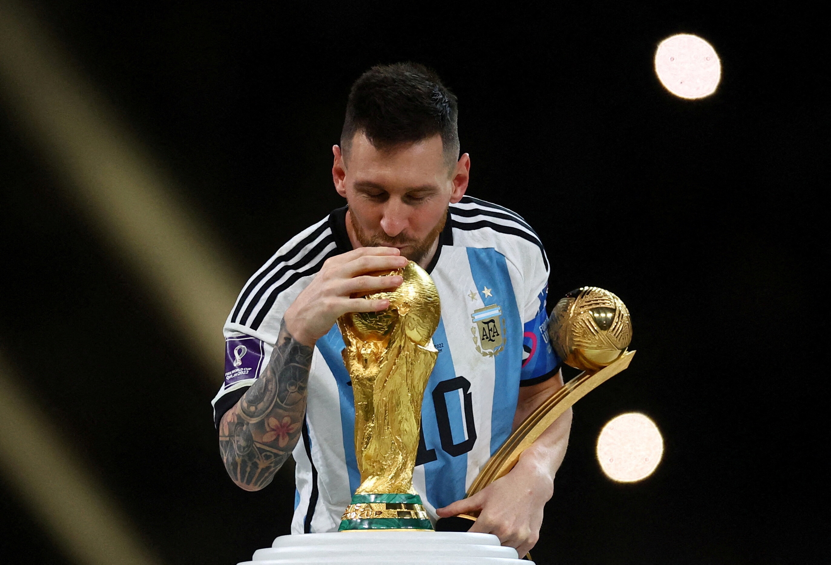 Soccer Football - FIFA World Cup Qatar 2022 - Final - Argentina v France - Lusail Stadium, Lusail, Qatar - December 18, 2022 Argentina's Lionel Messi kisses the World Cup trophy after receiving the Golden Ball award as he celebrates after winning the World Cup REUTERS/Kai Pfaffenbach/File Photo
