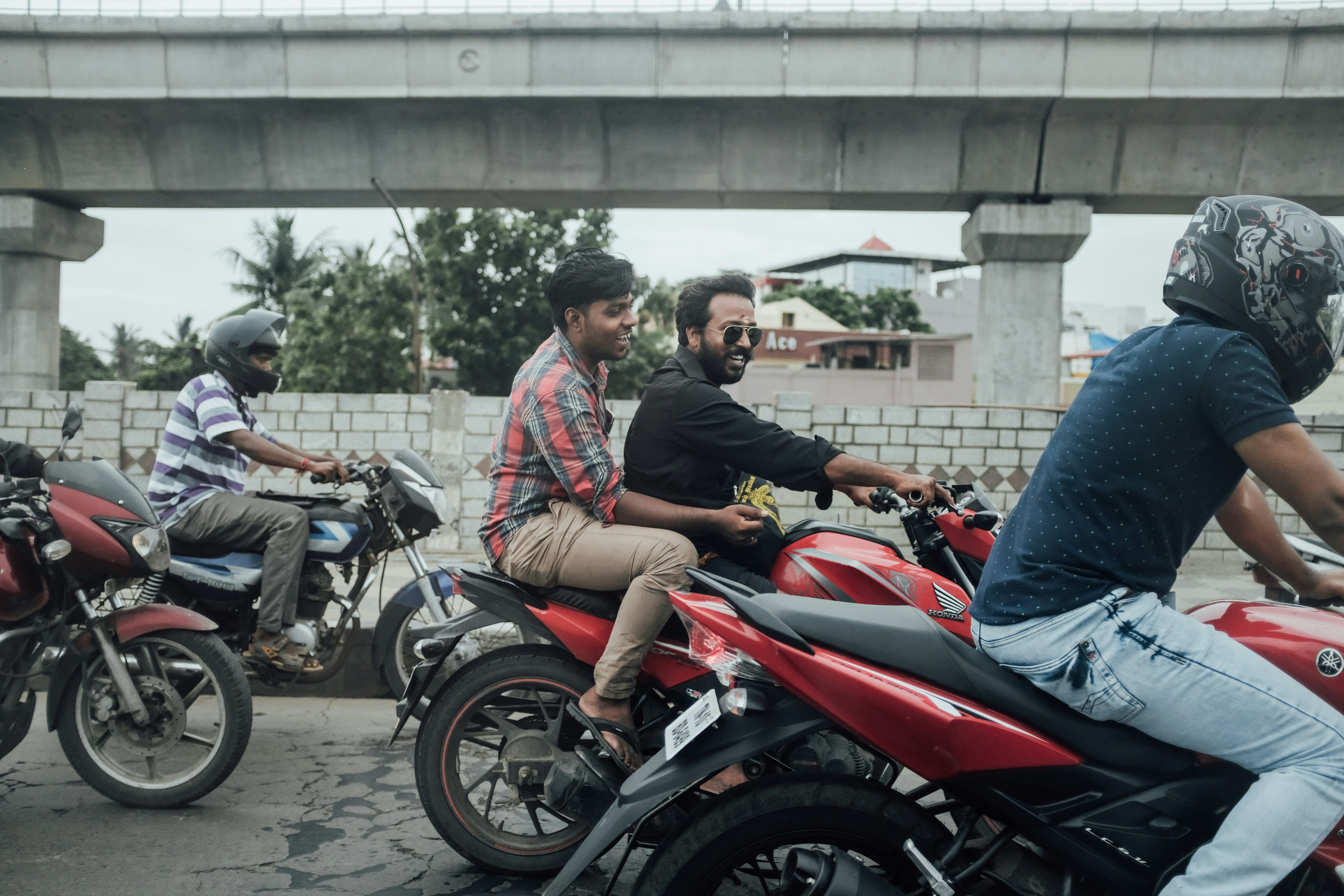 Men riding motorcycles, some wearing motorcycle helmets