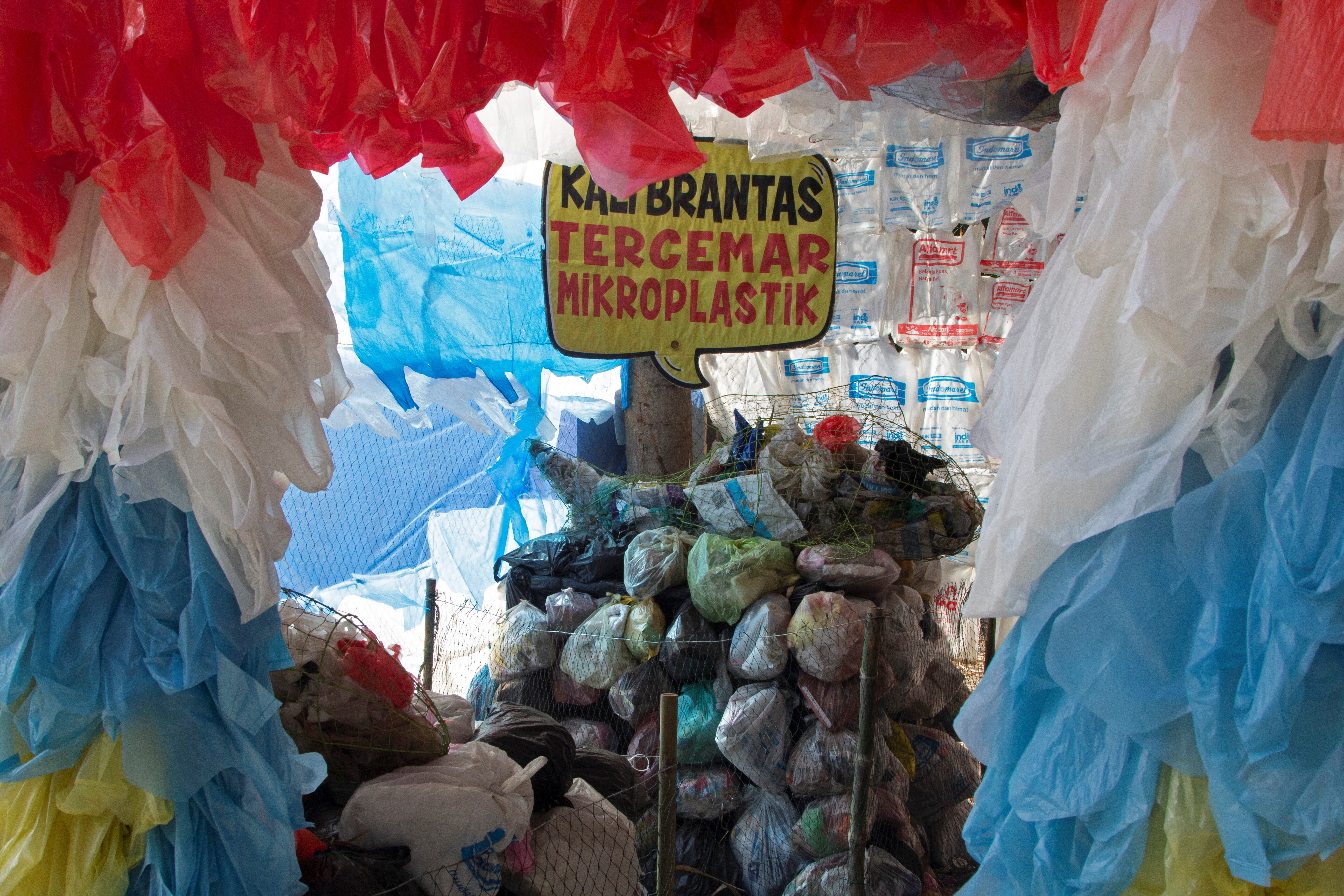A placard that reads "Brantas river polluted with microplastic" is seen among plastic bags displayed at the plastic museum constructed by Indonesia's environmental activist group Ecological Observation and Wetlands Conservation (ECOTON) in Gresik regency near Surabaya, East Java province, Indonesia, September 28, 2021: Plastic pollution solutions are underway at the national and grassroots levels