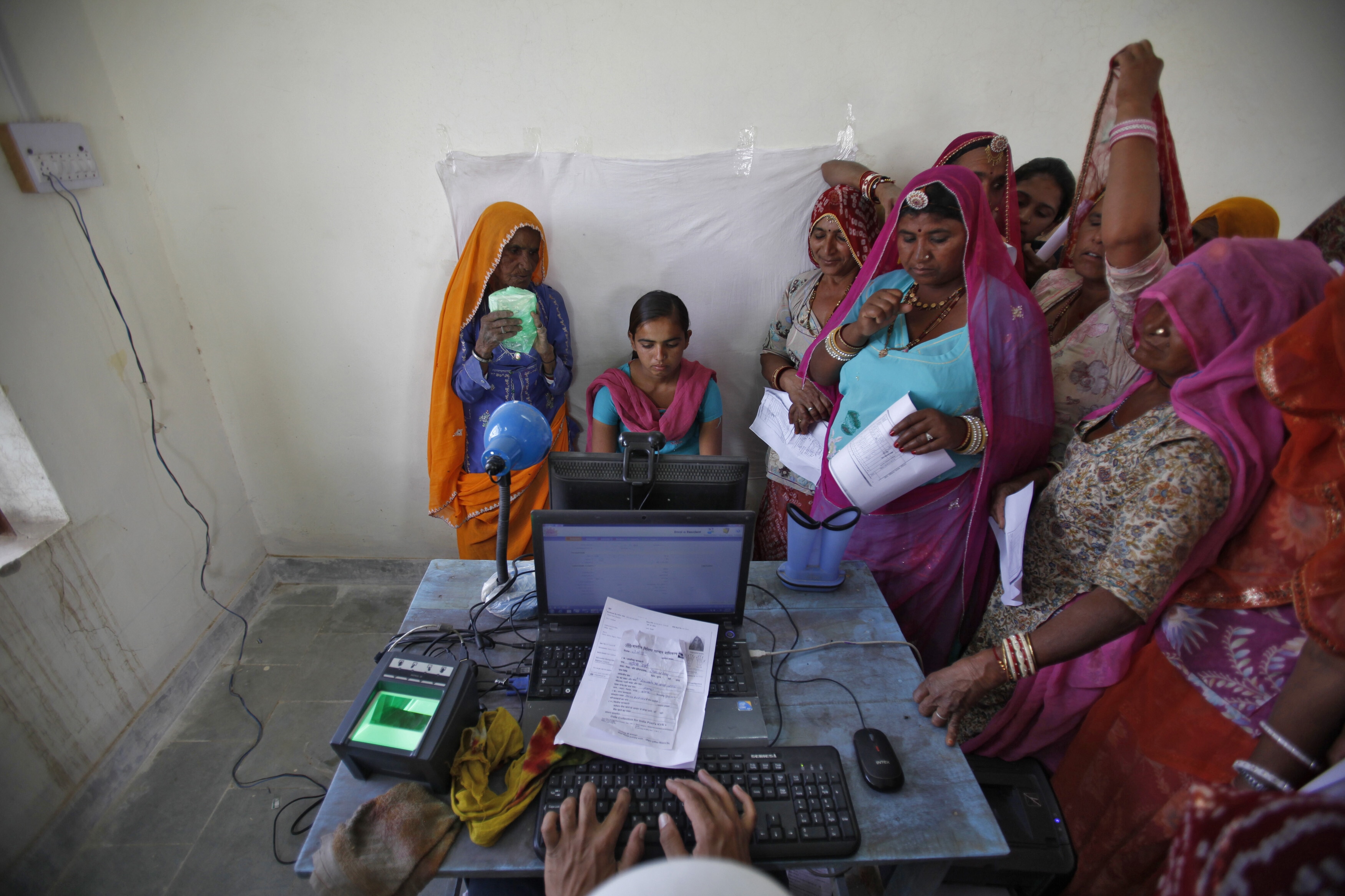 Village women stand in a queue to get themselves enrolled for the Unique Identification (UID) database system at Merta district in the desert Indian state of Rajasthan February 22, 2013. In a more ambitious version of programmes that have slashed poverty in Brazil and Mexico, the Indian government has begun to use the UID database, known as Aadhaar, to make direct cash transfers to the poor, in an attempt to cut out frauds who siphon billions of dollars from welfare schemes. Picture taken February 22, 2013. REUTERS/Mansi Thapliyal (INDIA - Tags: BUSINESS SOCIETY POVERTY SCIENCE TECHNOLOGY) Intelligence age
