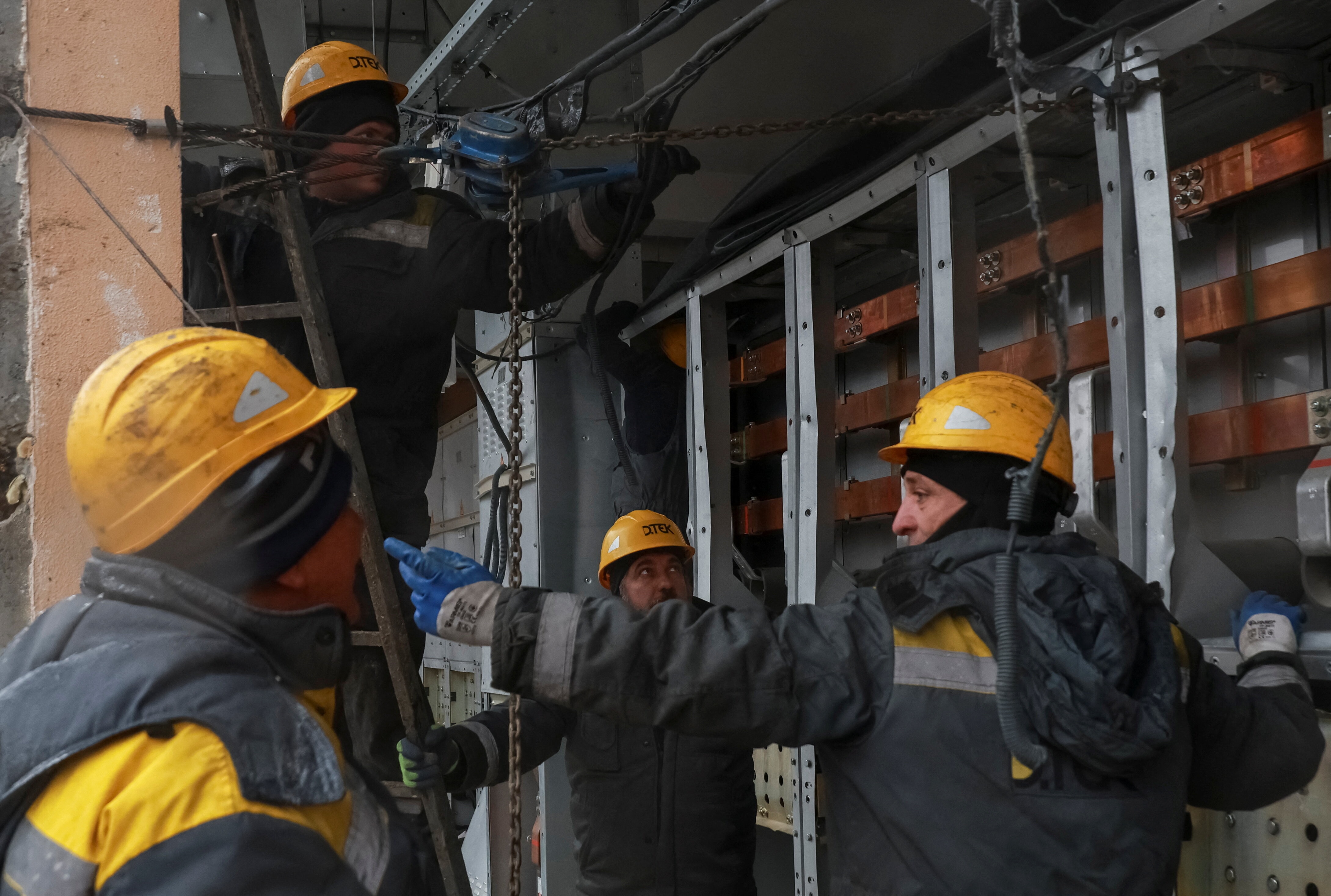 Workers in Odesa repair a power substation damaged by a Russian drone and missile strike.