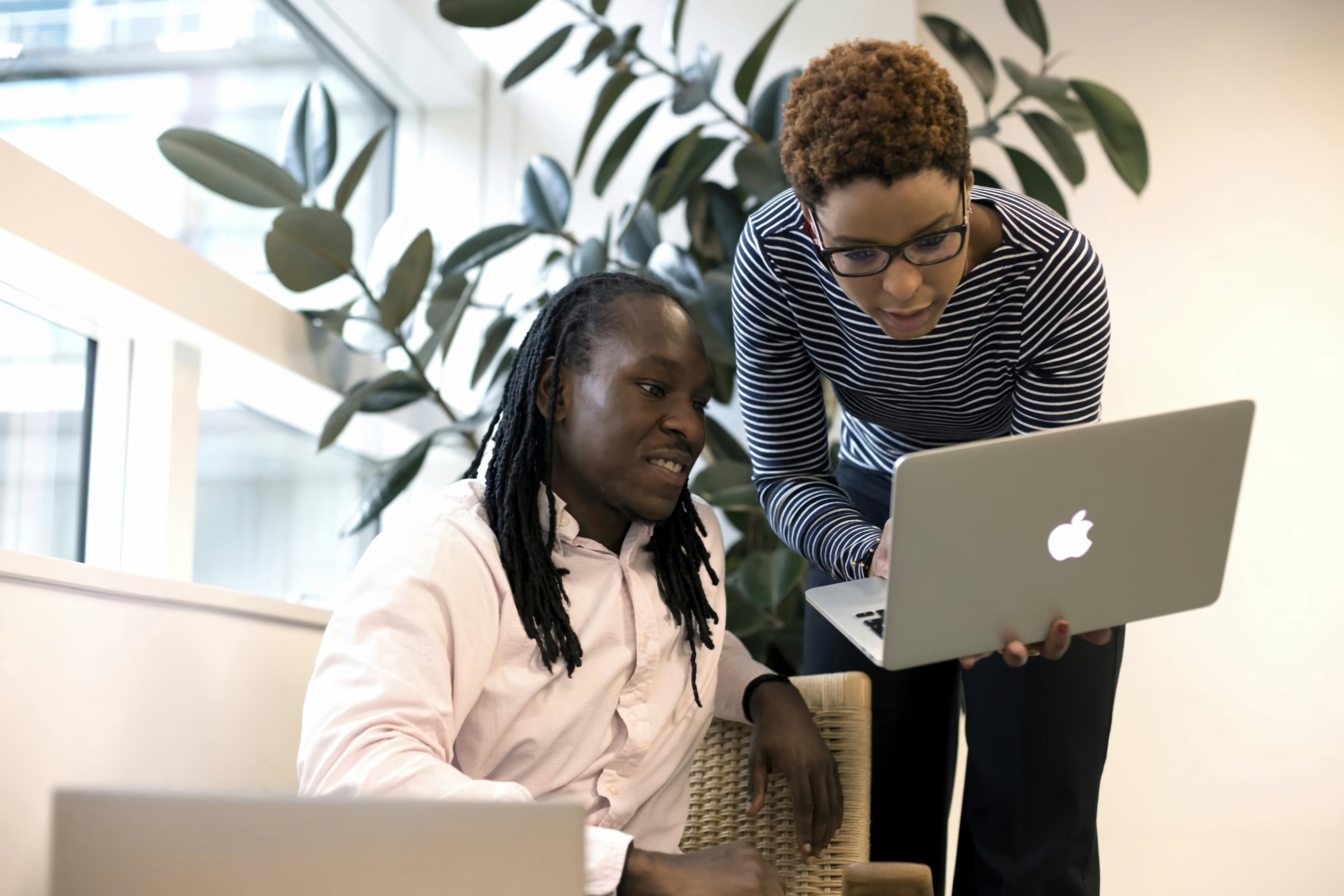 Two people in an office setting look at a laptop; skills transformation
