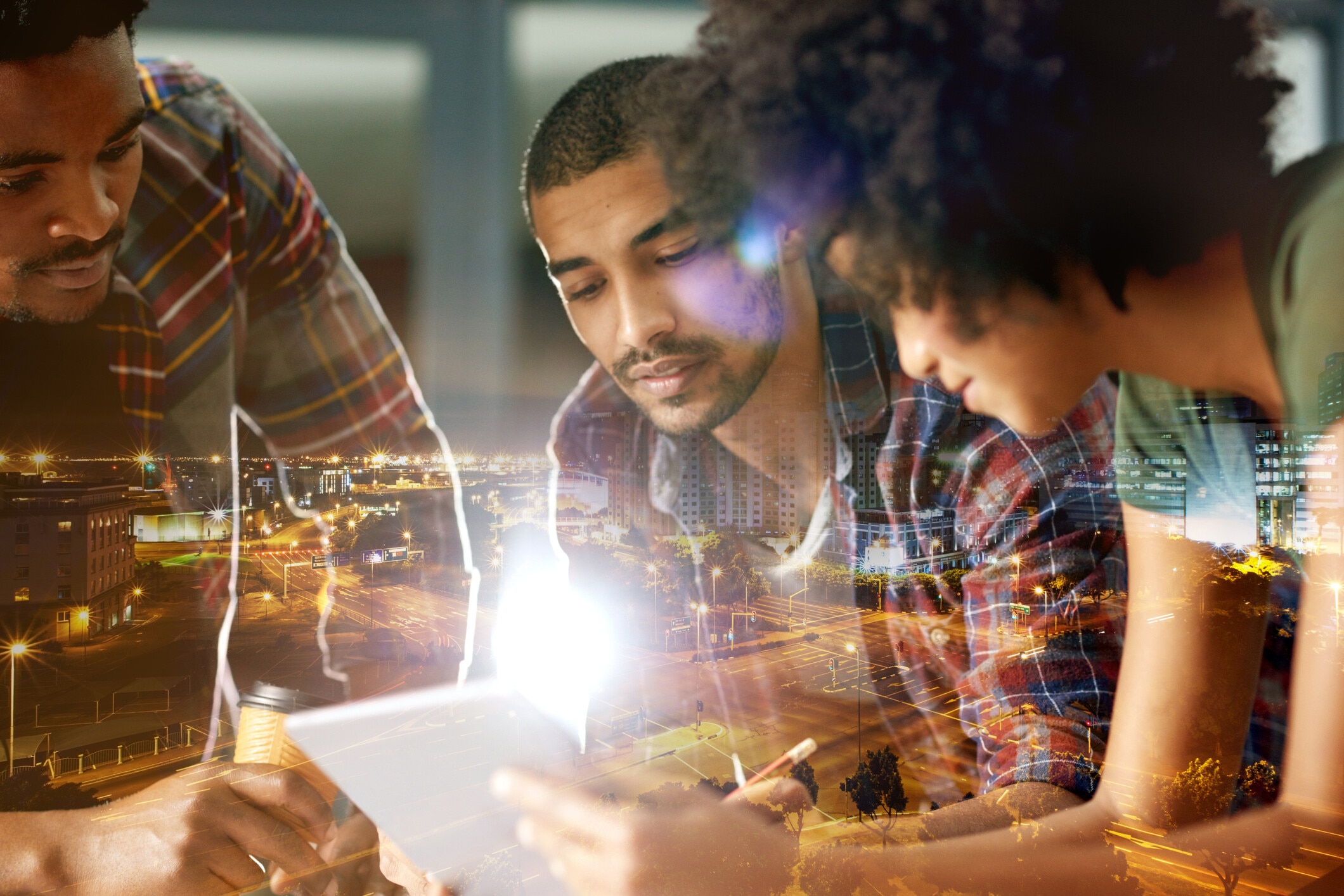 Multiple exposure shot of a team of creatives using a digital tablet superimposed over a city background at night; AI innovation