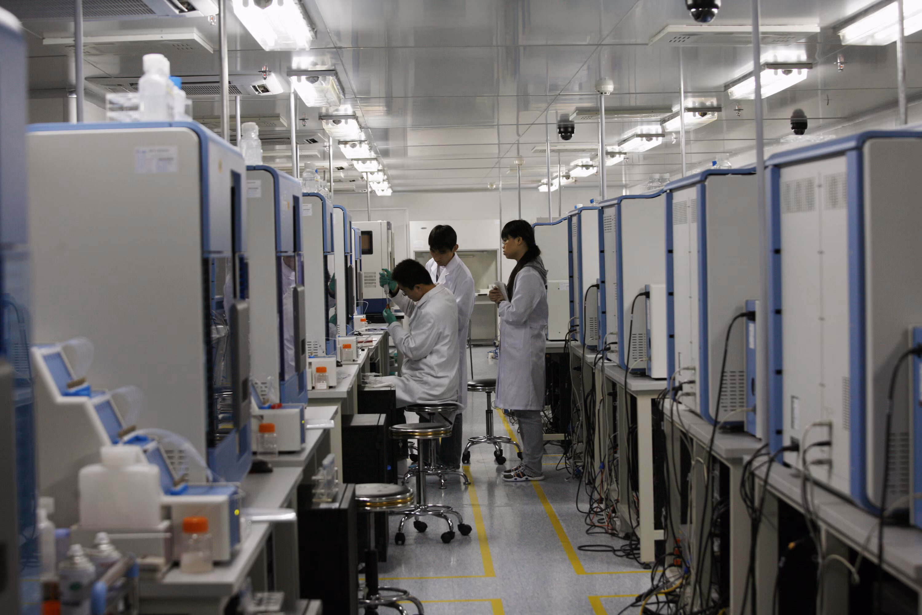 Three pharma workers are seen working in a lab in China.