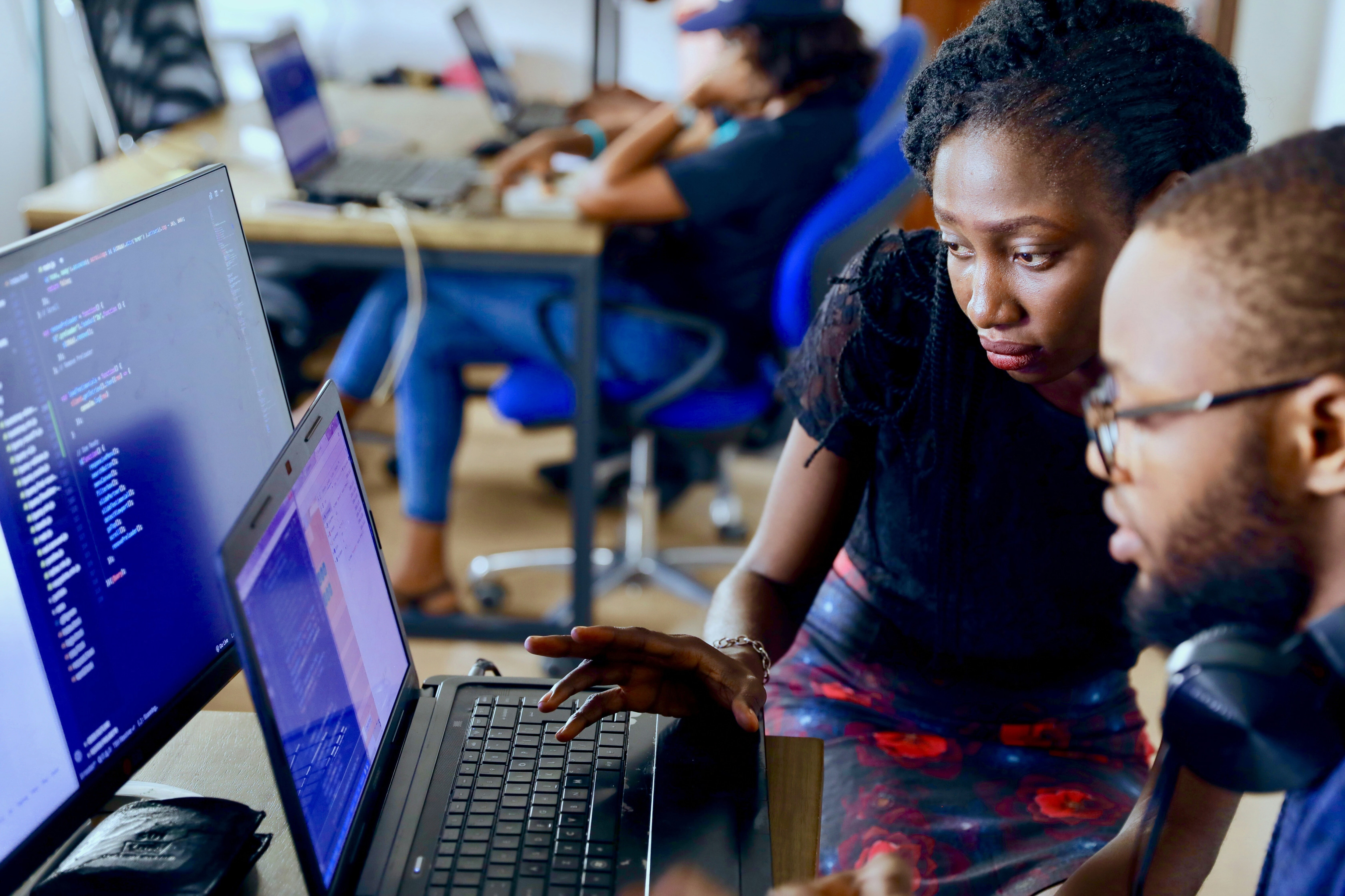 Two people coding at a computer.