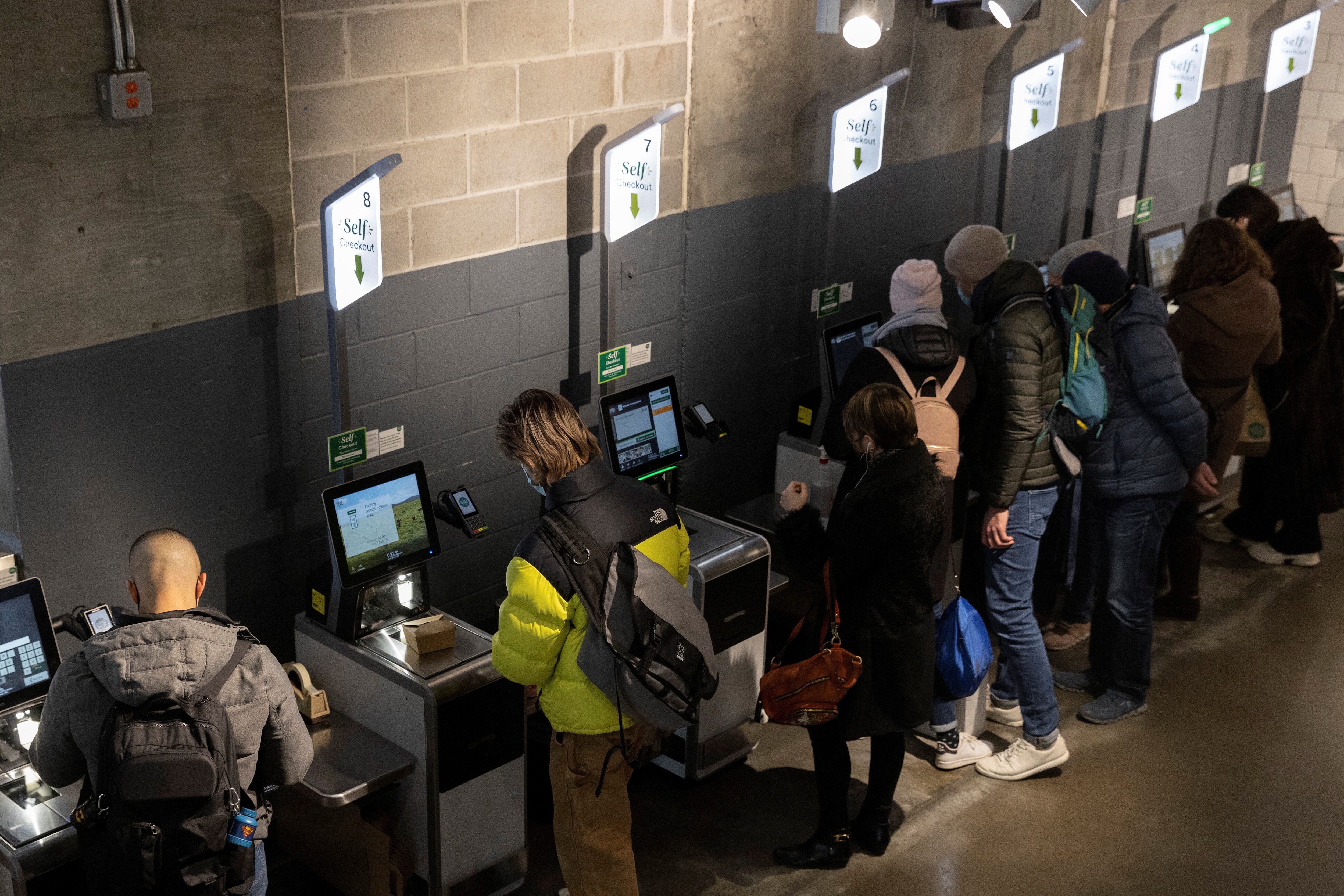 People pay for their purchases with self-checkout at a supermarket in Manhattan, New York City, U.S., March 28, 2022. REUTERS/Andrew Kelly