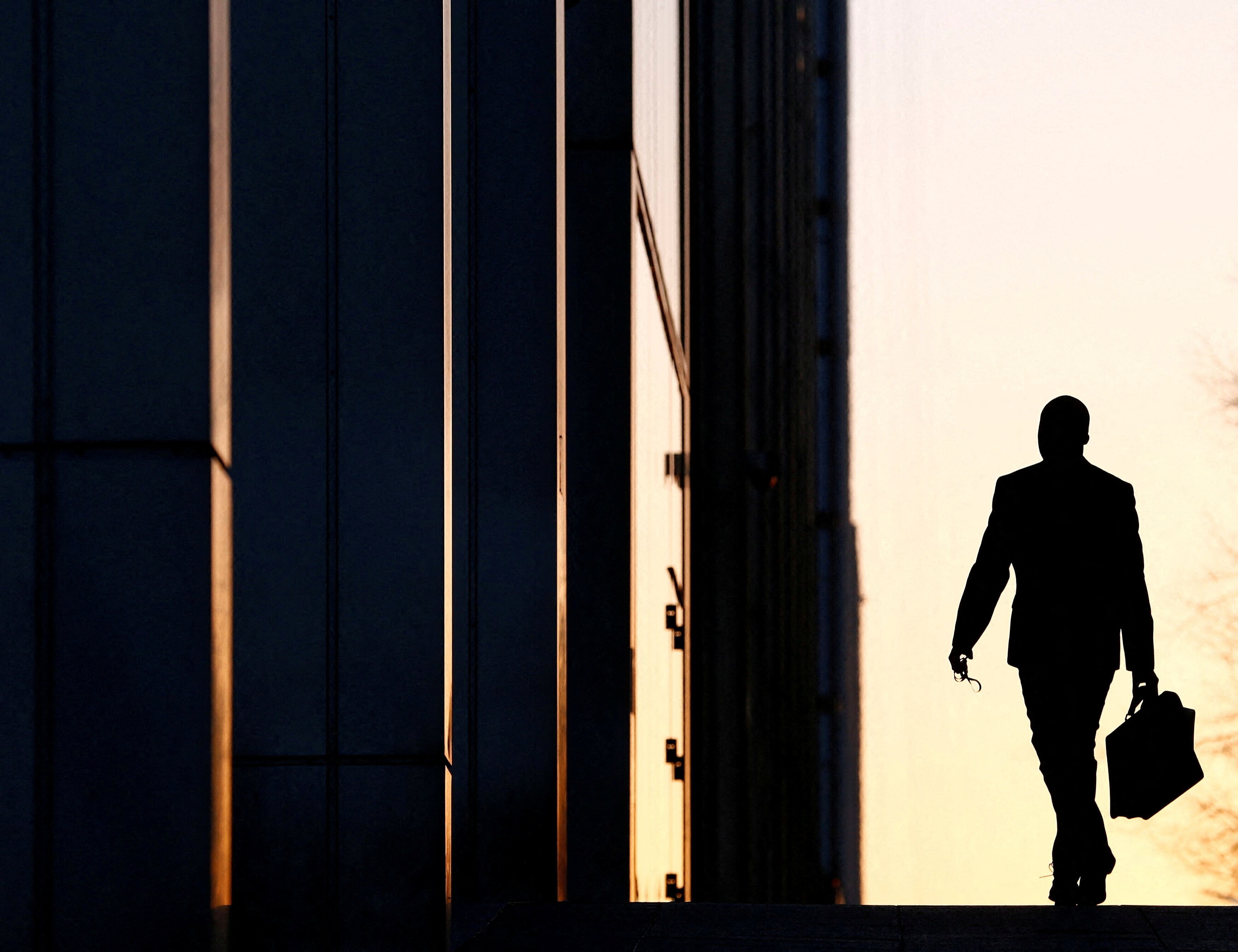 Un trabajador llega a su oficina en el distrito financiero de Canary Wharf, en Londres, el 26 de febrero de 2014/Foto de archivo.