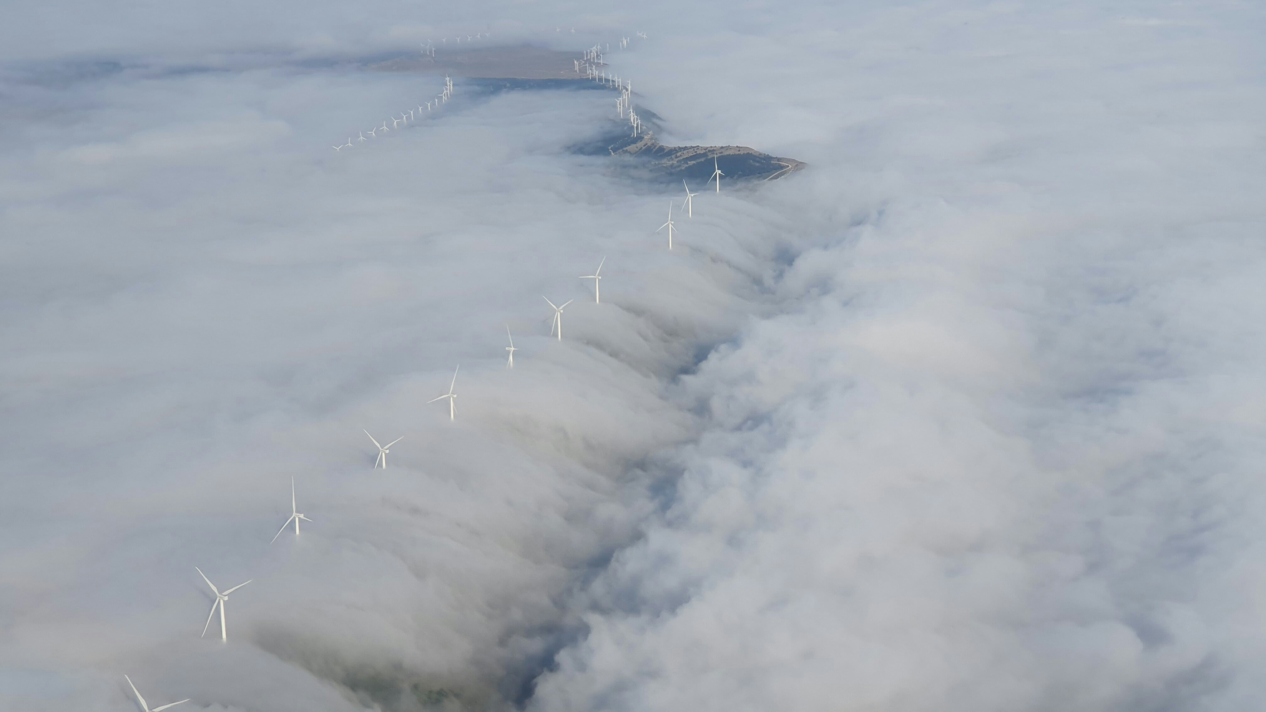 Wind turbines are pictured above clouds in Aliaga, Teruel, Spain.