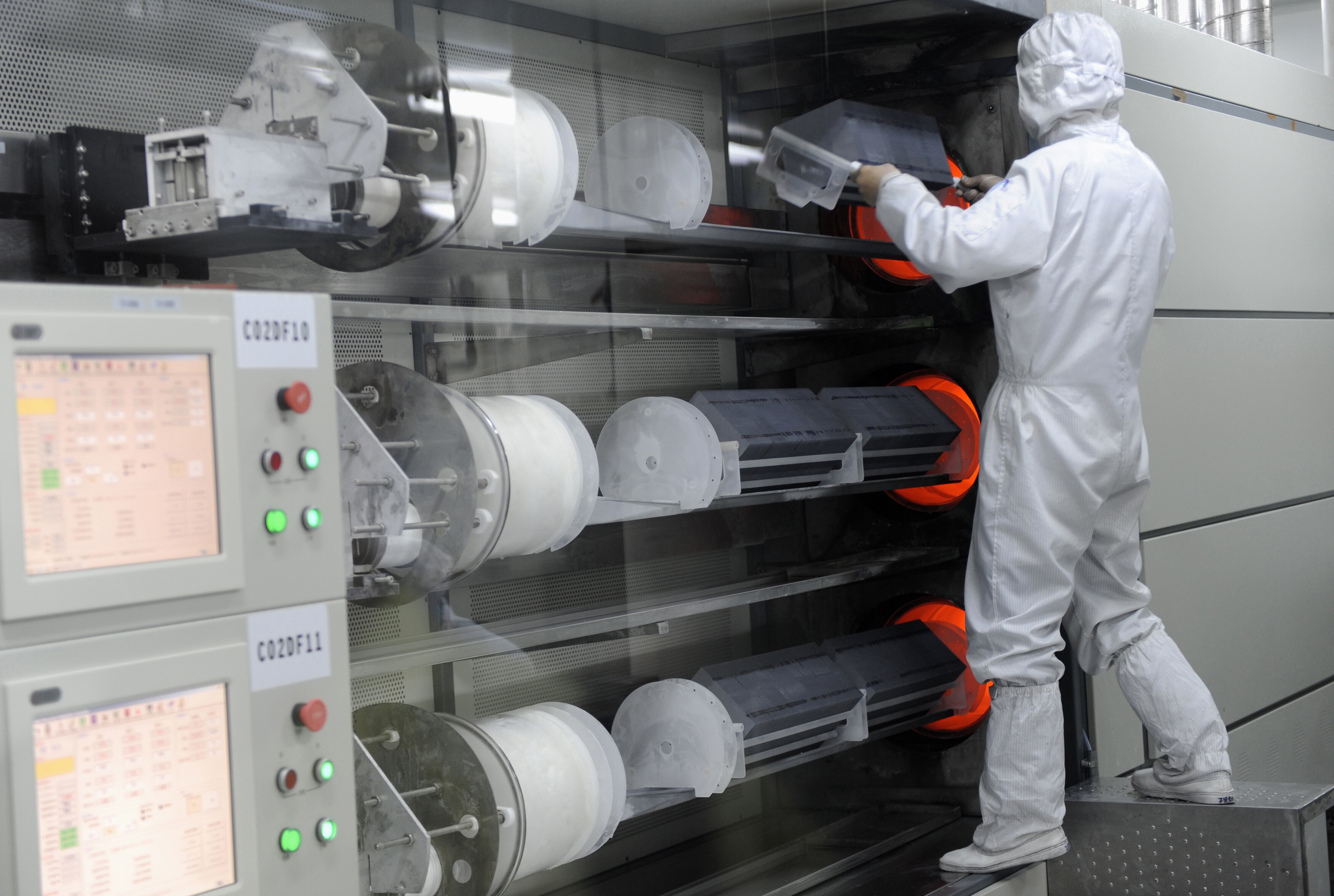 An employee takes out solar panels from an high temperature device at a workshop in Chint Solar Co. Ltd. factory in Hangzhou, Zhejiang province February 10, 2010: Biomanufacturing is shifting from niche climate solution to being foundational to the global economy