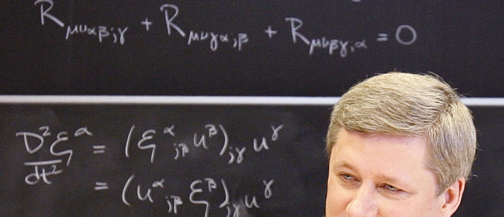 Canadian Prime Minister Stephen Harper sits in front of a blackboard containing mathematical equations while announcing a funding boost for science and technology at the Perimeter Institute for Theoretical Physics in Waterloo, May 17, 2007.     REUTERS/J.P. Moczulski (CANADA) - GM1DVGYIALAA