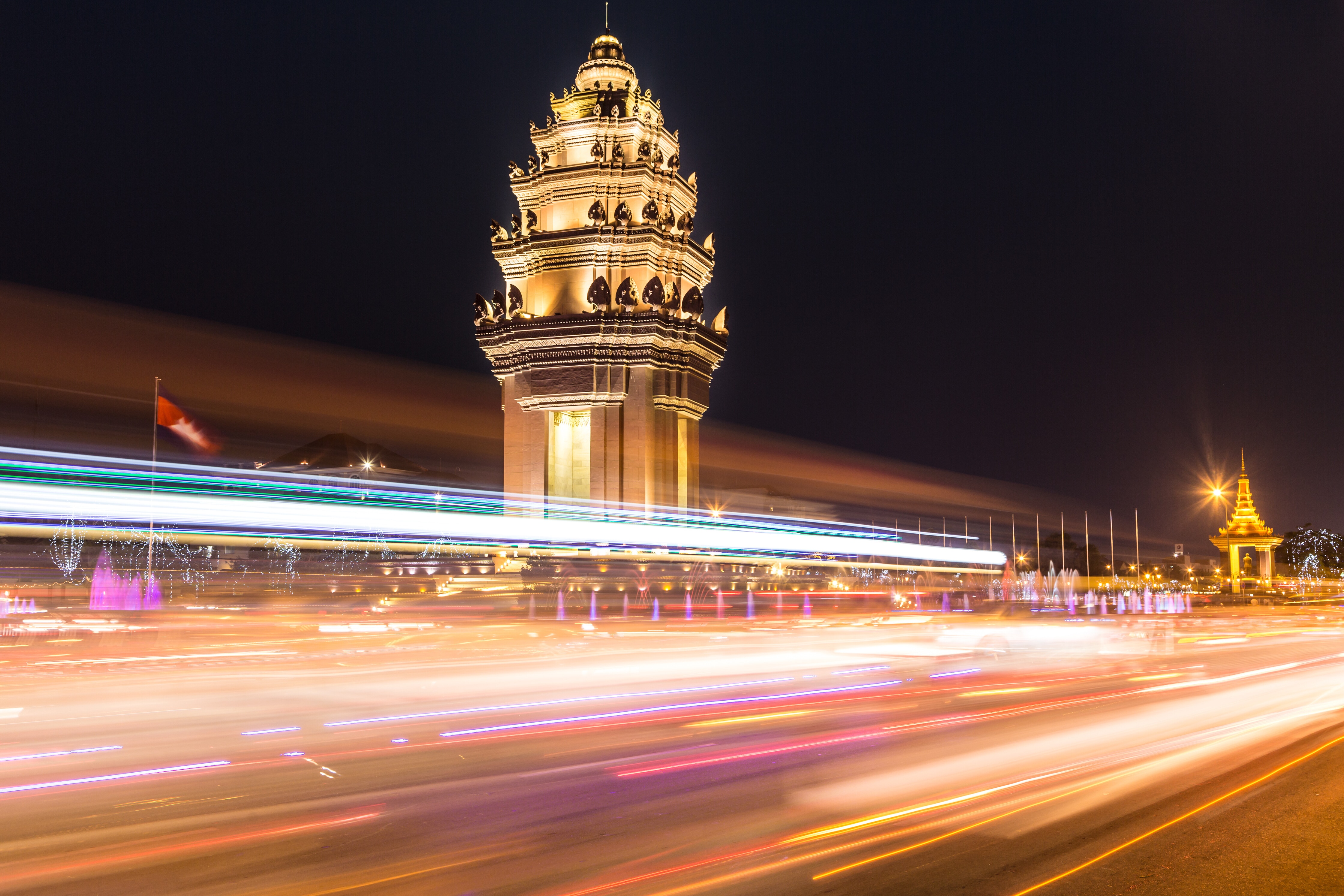 Traffic, captured with blurred motion, rush in front of the Independance monument at night in the heart of Phnom Penh at night in Cambodia capital city; digital economy
