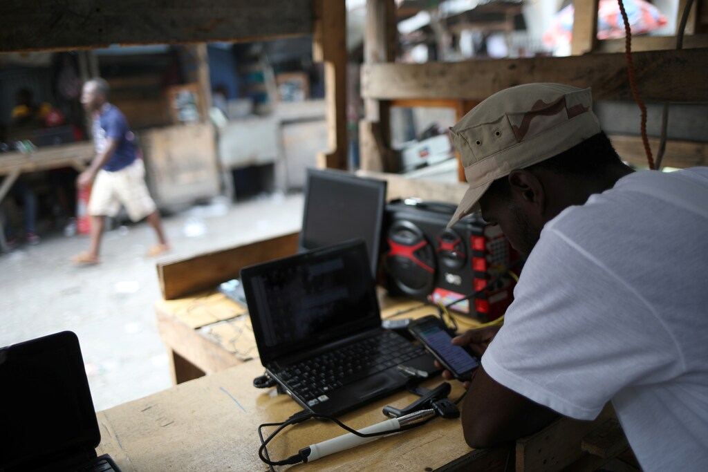A man waits for customers at a phone stand, Port-au-Prince, Haiti.