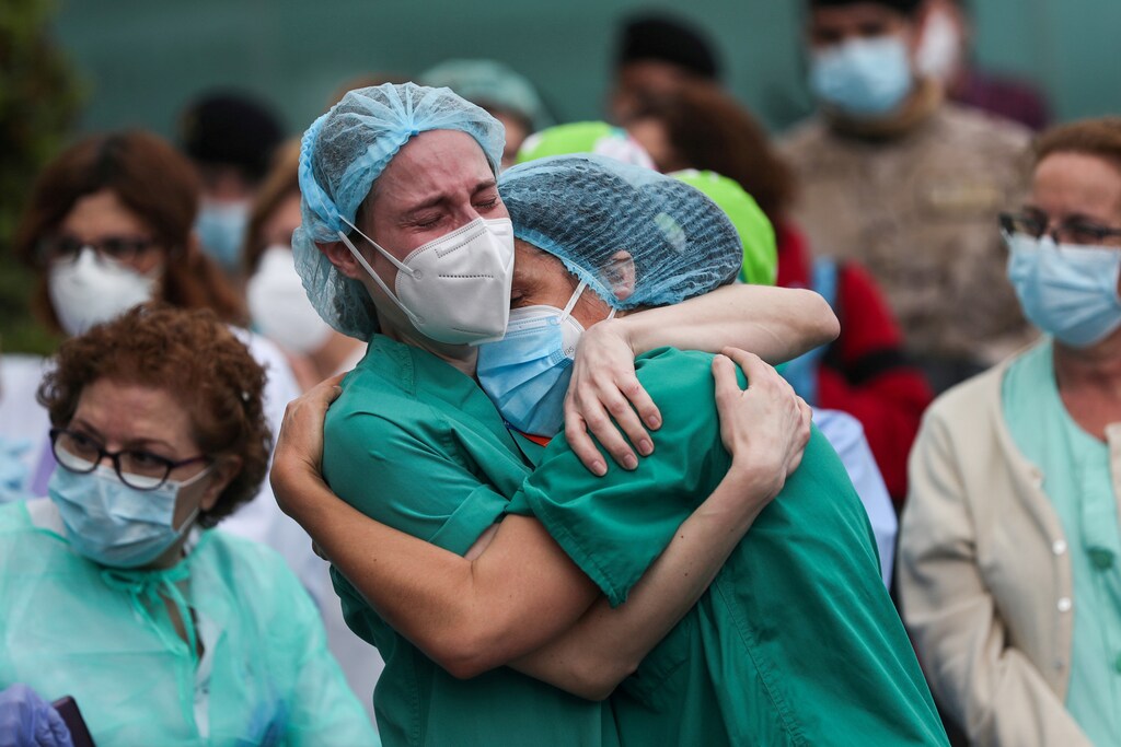 Health workers wearing protective face masks react during a tribute for their co-worker Esteban, a male nurse that died of the coronavirus disease, amid the coronavirus disease (COVID-19) outbreak, outside the Severo Ochoa Hospital in Leganes, Spain, April 13, 2020. REUTERS/Susana Vera TPX IMAGES OF THE DAY - RC2N3G9J7MA2