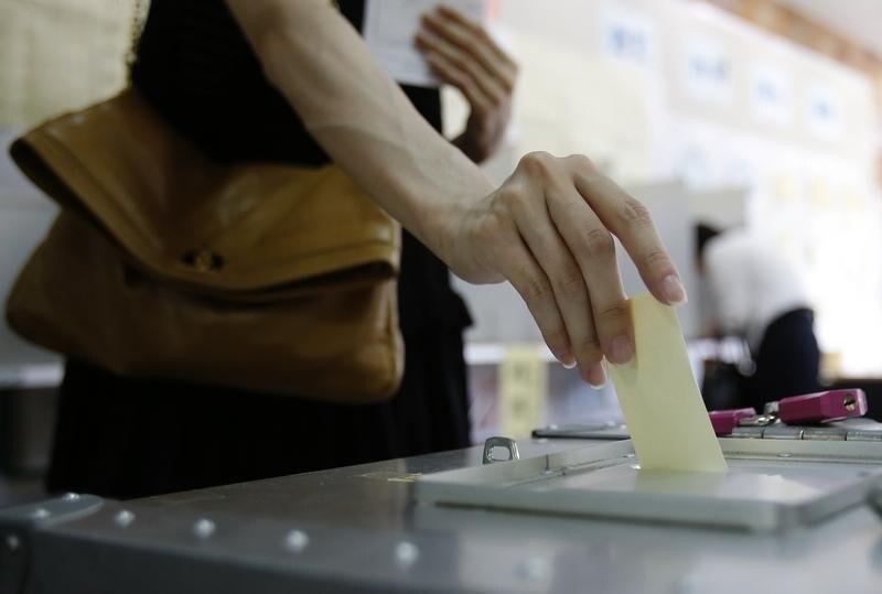 A woman casts her ballot at a polling station in Tokyo July 21, 2013. Prime Minister Shinzo Abe's ruling bloc looks set for a handsome upper house election win on Sunday, cementing his grip on power and setting the stage for Japan's first stable government since the charismatic Junichiro Koizumi left office in 2006.