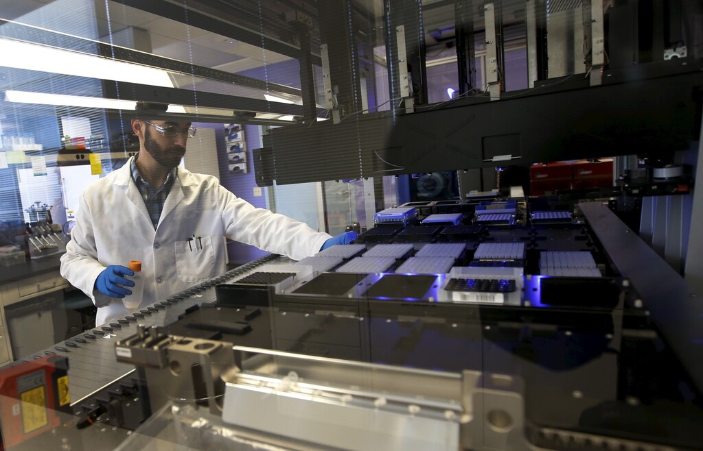 Technician Matthew Smith loads a robotic DNA sample automation machine at a Regeneron Pharmaceuticals Inc. laboratory at the biotechnology company's headquarters in Tarrytown, New York March 24, 2015.