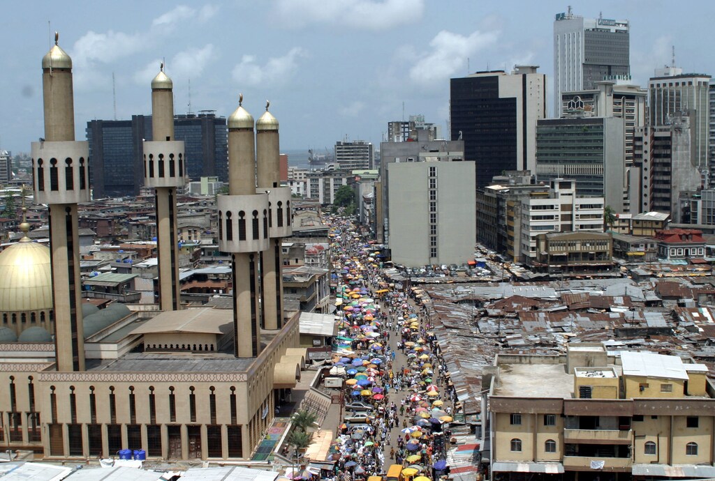 People and traffic move along a busy street in Lagos, Nigeria, May 24,2005. The African Union (AU) celebrates Africa Day on Wednesday May 25, marking the anniversary of the founding in 1963 of the Organization of African Unity, replaced in 2002 by the AU as the driving force behind the struggle for peace, democracy, development, human rights and good governance on the worlds poorest continent. REUTERS/George Esiri FOR/LA - RP6DRMSWTKAA