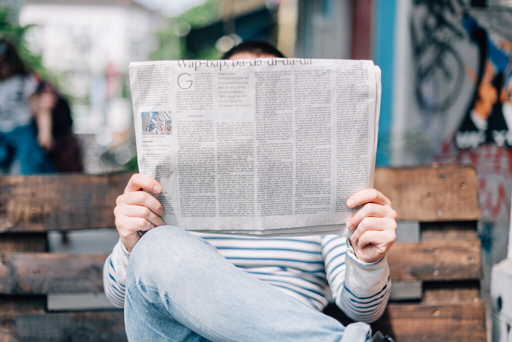 Person reading a newspaper. Gender inequalities, Russian debt default and slowing shipping - here are the latest economic stories.