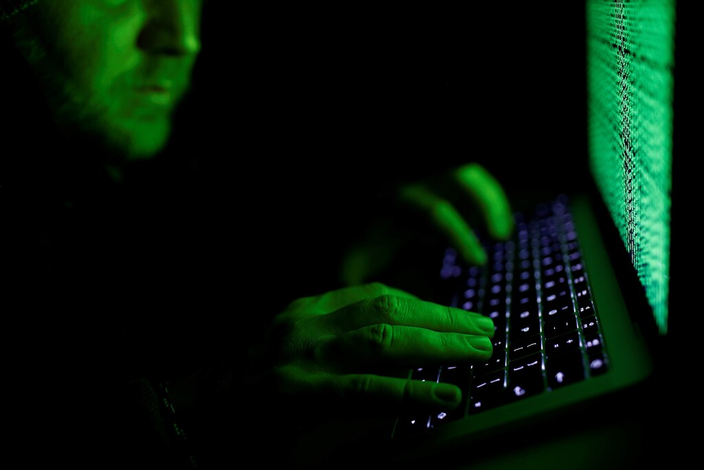 A man types on a computer keyboard in front of the displayed cyber code in this illustration picture taken on March 1, 2017.