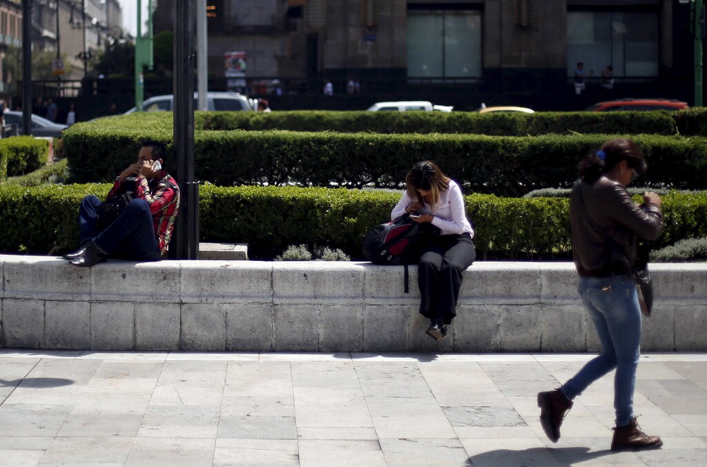 People use their cell phones in Mexico City, October 8, 2015.