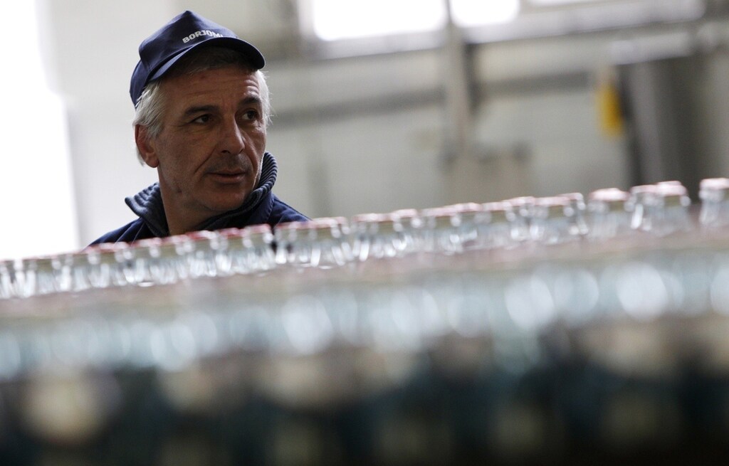 An employee works at the production line of the IDS Borjomi Georgia's factory in the town of Borjomi, some 150 km (93 miles) southwest of Tbilisi, January 30, 2013. If there's a secret to taking the bitter taste out of ties between Russia and Georgia after a 2008 war, it may lie in this lush valley south of the Caucasus Mountain border between the feuding former Soviet republics. The valley is the source of Borjomi, a salty, sulphurous mineral water that was popular in Russia since Soviet times but was swept off shelves when Moscow banned imports of Georgian beverages in 2006, with tensions already building toward war. Picture taken January 30. To match story GEORGIA-RUSSIA/TALKS REUTERS/David Mdzinarishvili (GEORGIA - Tags: BUSINESS POLITICS) - RTR3D8PG