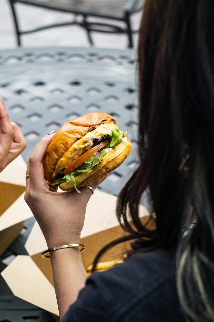 A hand holding a beef burger -- burgers could be responsible for a rise in autoimmune diseases