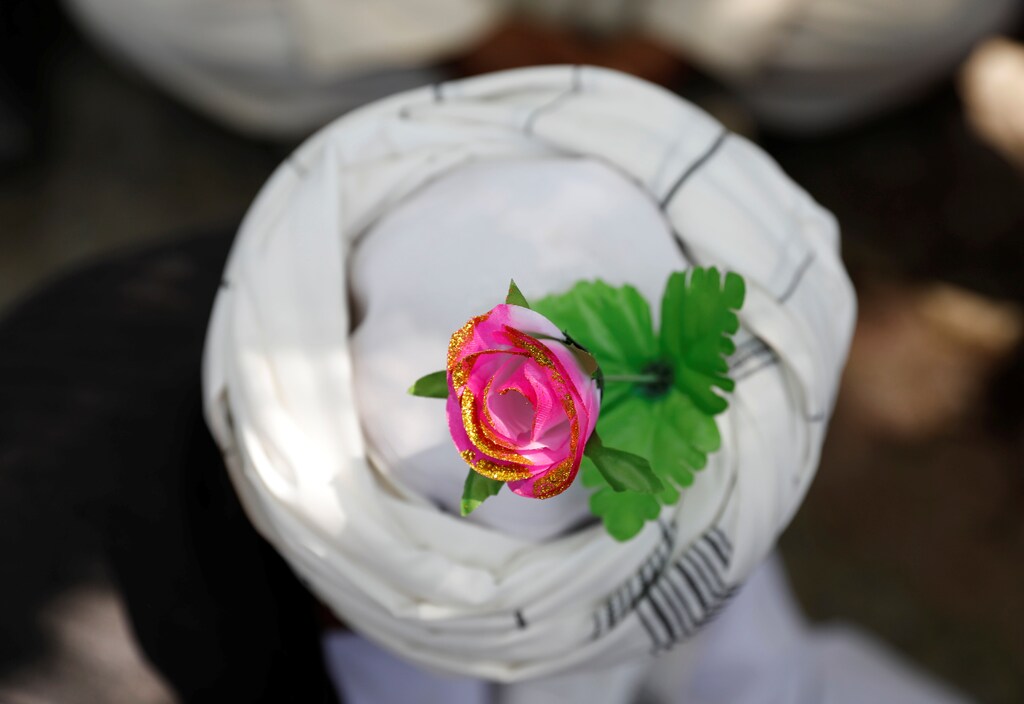An artificial flower is seen on a turban of a peace marcher as he arrives in Kabul, Afghanistan June 18, 2018. REUTERS/Mohammad Ismail - RC1DB57089A0