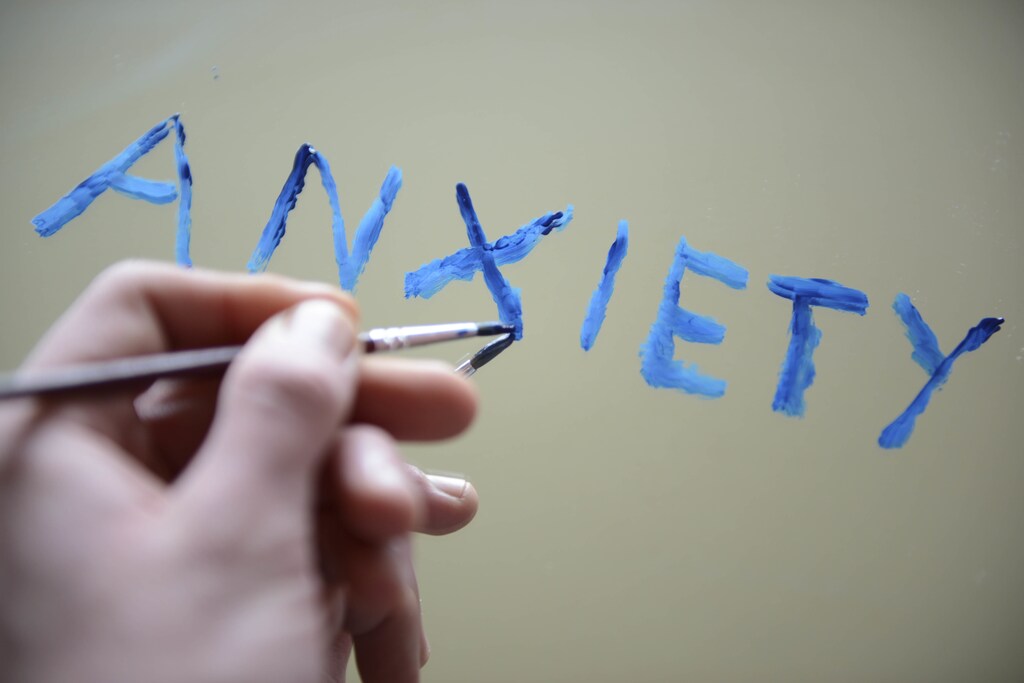 Anxiety word being painted on a mirror