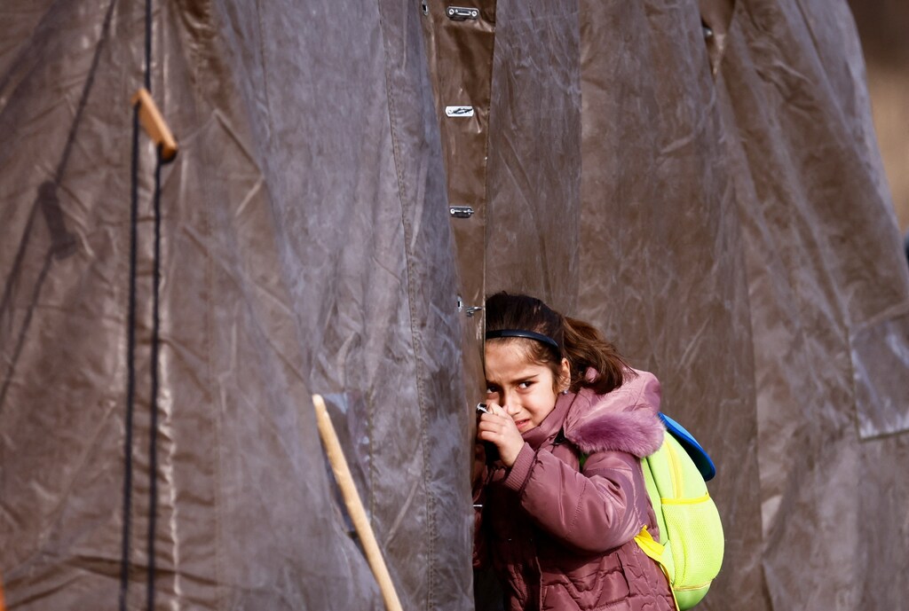 A child fleeing Russian invasion of Ukraine reacts as she stands outside the tent, at a temporary camp in Przemysl, Poland, March 1, 2022. REUTERS/Yara Nardi