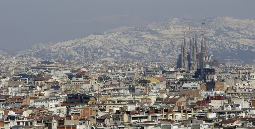 Gaudi's Sagrada Familia and Barcelona's skyline are seen against the backdrop of a snow-covered mount after a snowstorm March 9, 2010. REUTERS/ Albert Gea (SPAIN - Tags: ENVIRONMENT CITYSCAPE) - GM1E6391P7R01