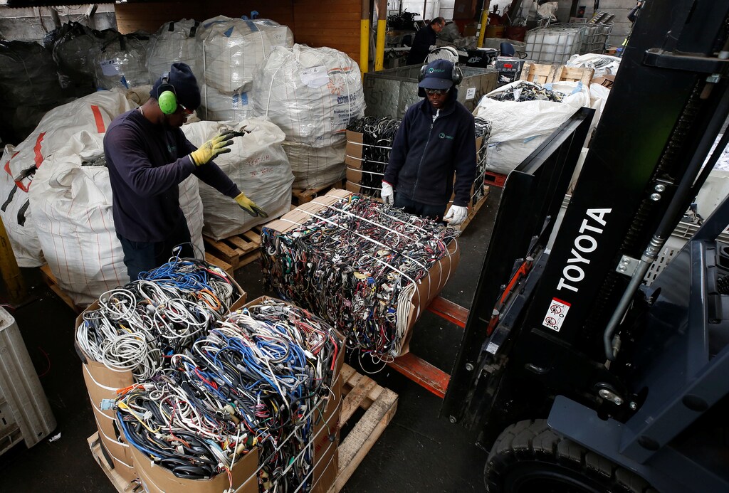 Employees move packs of electrical cable waste at a recycling plant in Santiago, Chile.