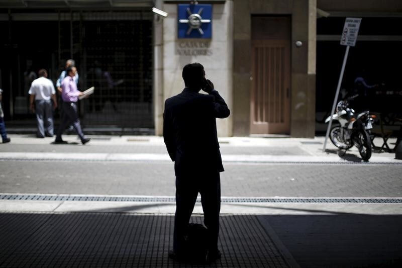 A man uses his mobile phone outside Buenos Aires stock exchange building, Argentina, November 23, 2015. Argentine bond prices were giving back some earlier gains on Monday as investors took profits following a widely expected victory for market favorite Mauricio Macri in the presidential elections over the weekend. REUTERS/Ivan Alvarado - GF20000071137