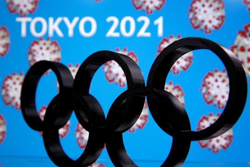 A 3D printed Olympics logo is seen in front of displayed "Tokyo 2021" words in this illustration taken March 24, 2020. REUTERS/Dado Ruvic - RC2DQF9V5DX2