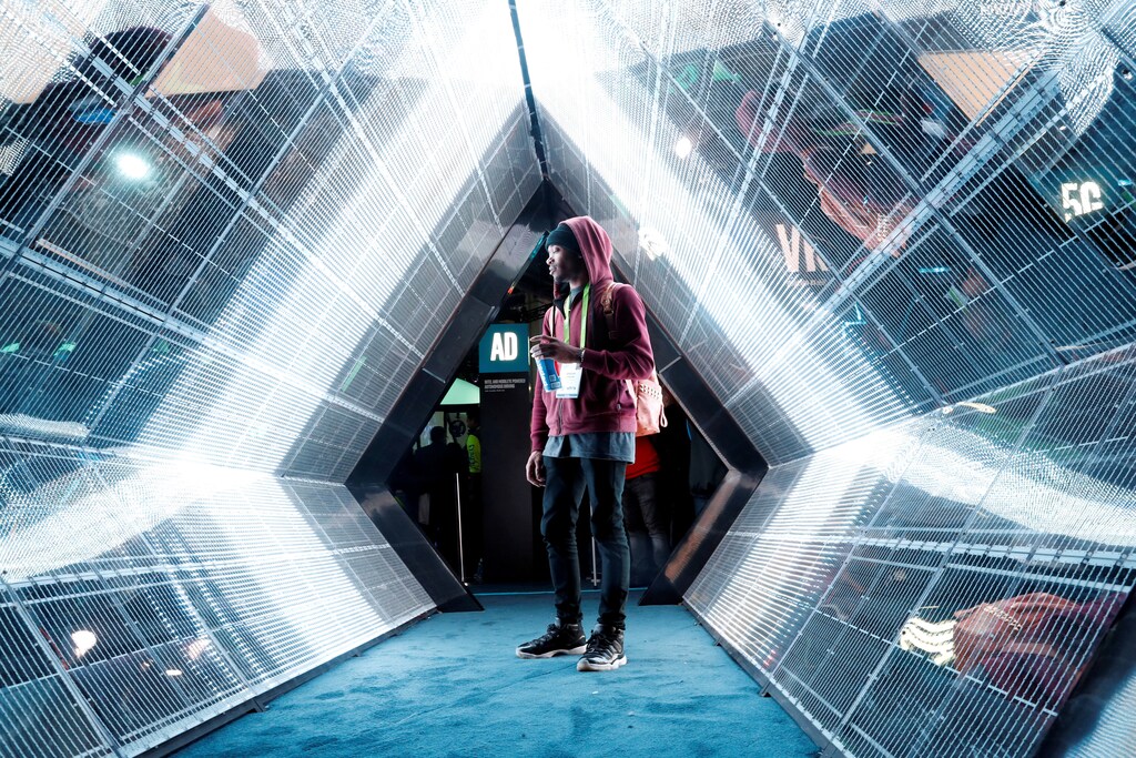 Jordan Jtakin walks though a 5G wireless broadband technology display in the Intel booth during the 2018 CES in Las Vegas, Nevada, U.S. January 9, 2018. REUTERS/Steve Marcus TPX IMAGES OF THE DAY - RC1CD0627130
