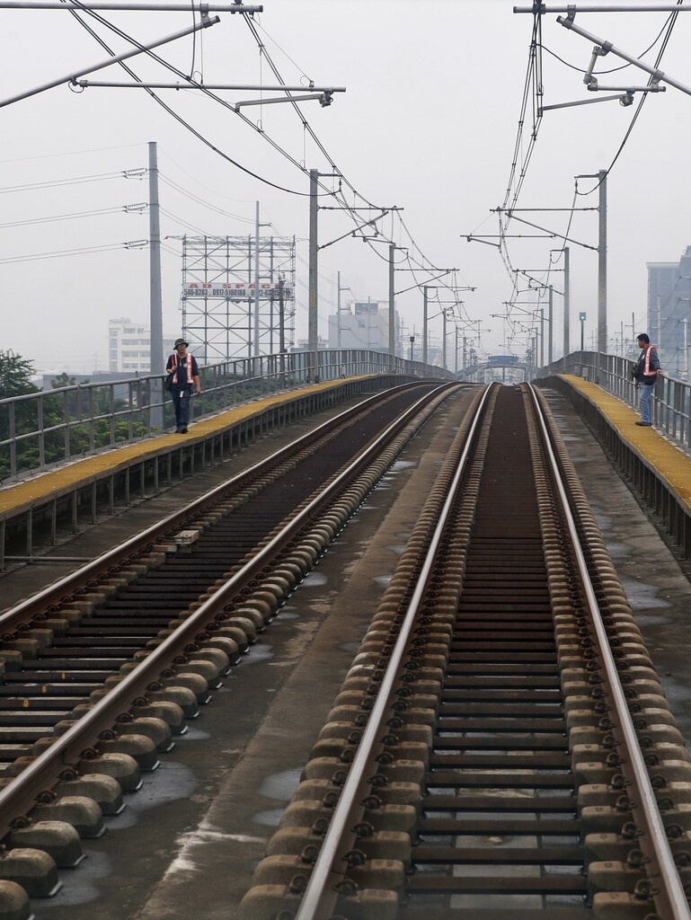 Workers inspect tracks on the railway of Southeast Asia's first light rail transit (LRT) network, which is 29-years-old, in Manila October 10, 2013. Images of a portion of the Philippines' oldest light rail transit line ablaze in the middle of the night were exactly what private sector bidders for a $1.4 billion rehabilitation of the country's rail system had feared. To match Insight PHILIPPINES-ECONOMY/ Picture taken October 10, 2013. REUTERS/Erik De Castro (PHILIPPINES - Tags: POLITICS BUSINESS TRANSPORT) - GM1E9AF0BHU01