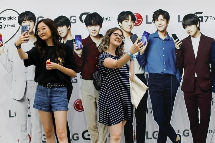 Attendees take selfies with cardboard cutout figures at KCON USA, billed as the world's largest Korean culture convention and music festival in Los Angeles, California, U.S. August 10, 2018. Picture taken on August 10, 2018. REUTERS/Mike Blake