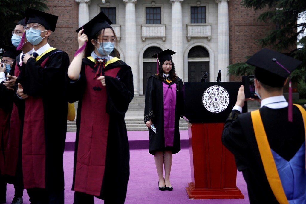 Undergraduate students pose for photos as they attend a graduation ceremony in Tsinghua University, following the outbreak of the coronavirus disease (COVID-19), in Beijing, China June 23, 2020. REUTERS/Tingshu Wang TPX IMAGES OF THE DAY - RC2SEH9SN936