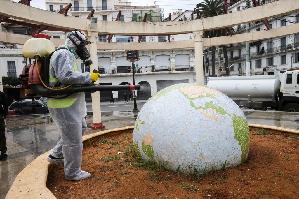 A worker wearing a protective suit disinfects a globe-shaped public garden, following the outbreak of coronavirus disease (COVID-19), in Algiers, Algeria March 23, 2020. REUTERS/Ramzi Boudina TPX IMAGES OF THE DAY - RC2SPF9I75BS